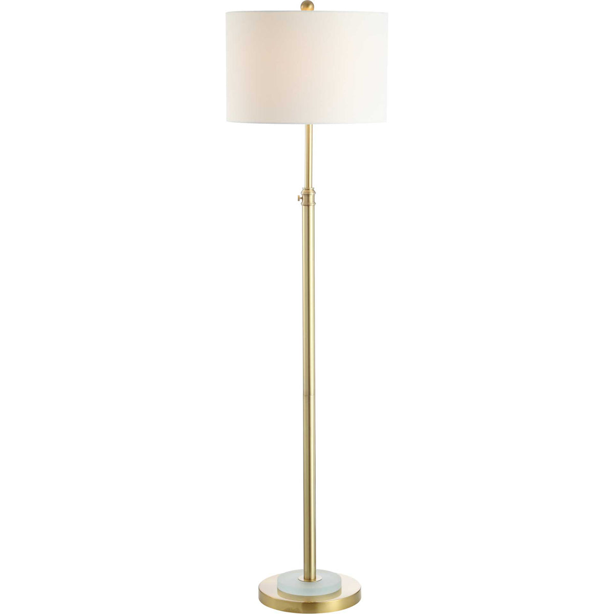 Warm light filters through an off-white drum shade above a slender brass-tone stem and crystal-accented base