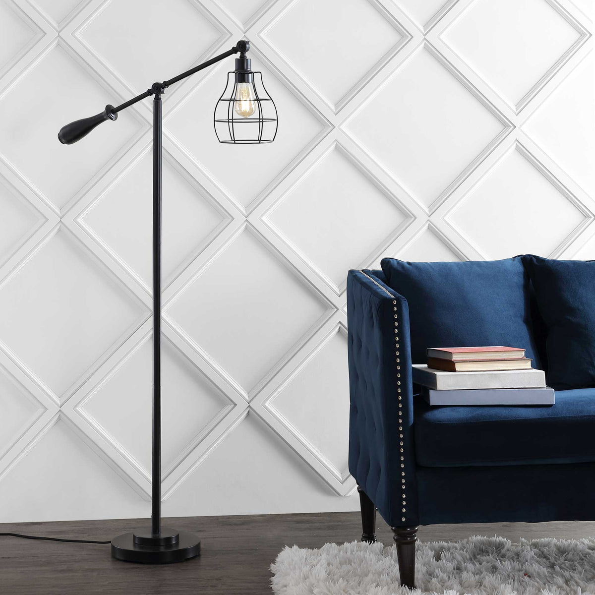 A caged bulb casts a warm glow beside a blue chair on this slender black floor lamp