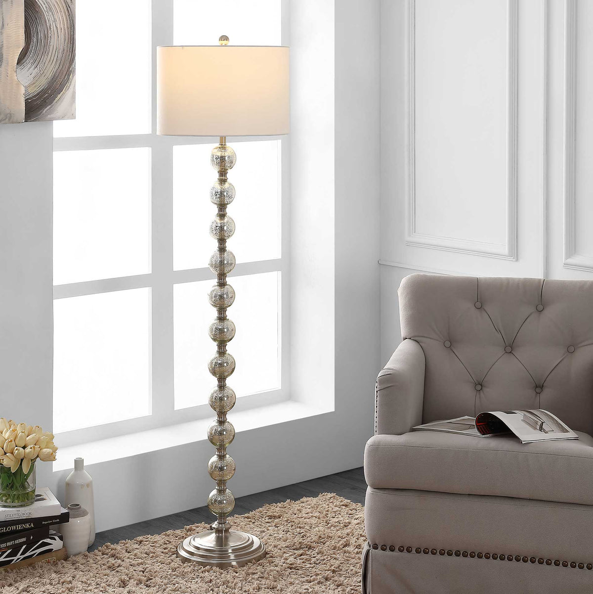 A softly glowing off-white shade crowns the sculptural glass-orb stem for inviting ambient light.