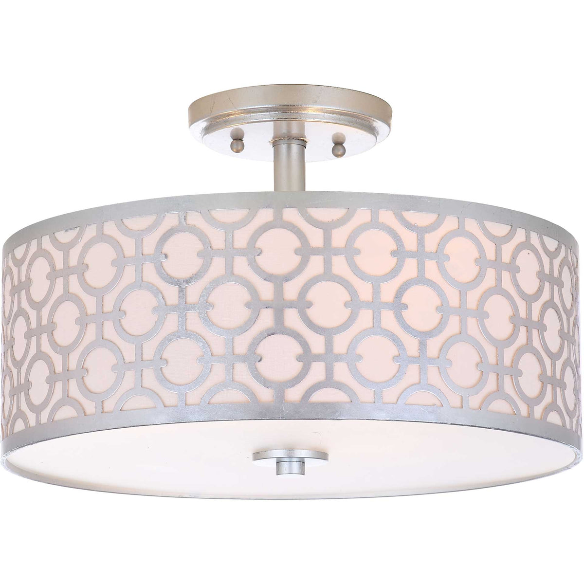 A warm glow shines through an off-white drum shade framed by a silver linked-circle design