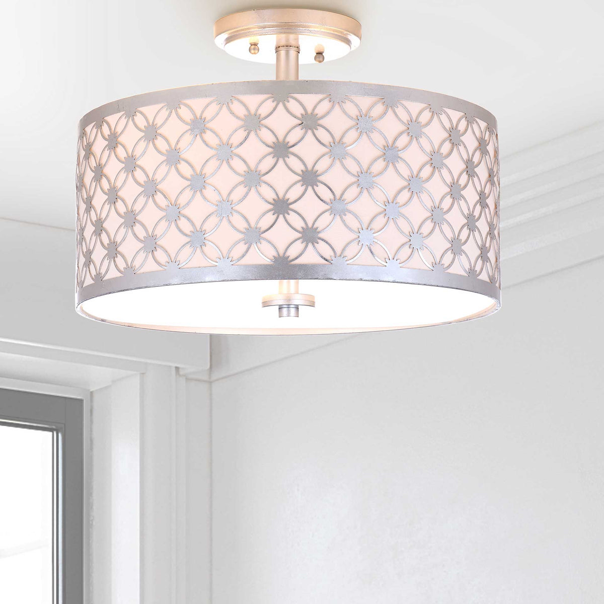 Warm light filters through a silver petal lattice and softly diffused drum shade