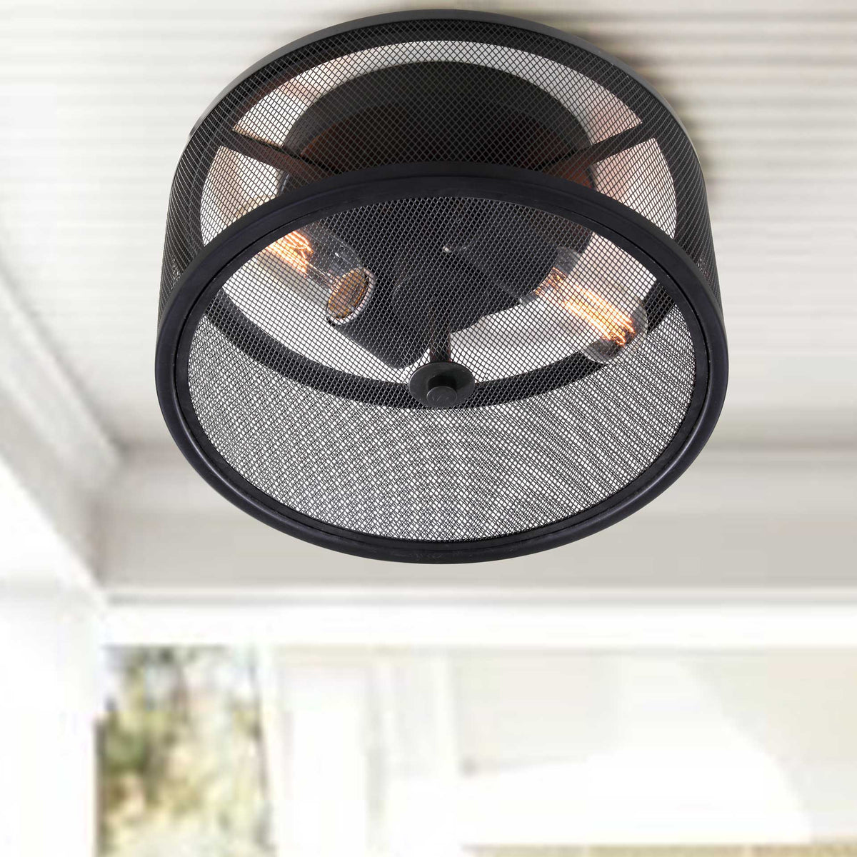 Warm light from two bulbs glows through the black metal mesh drum
