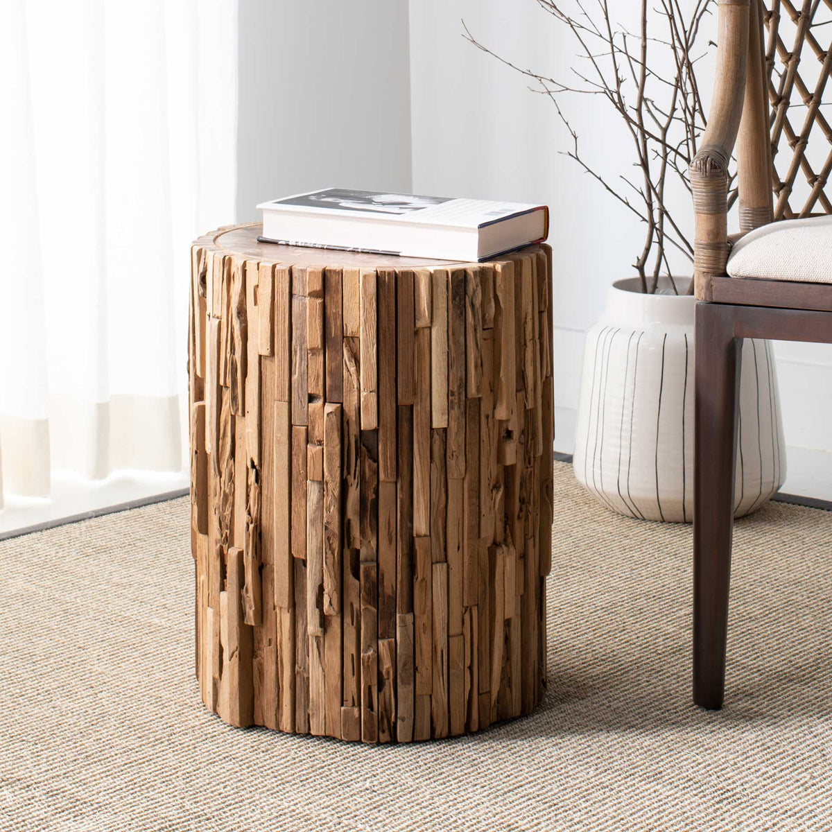 Sculptural teak stool doubles as a side table, with a round top and rustic wood texture