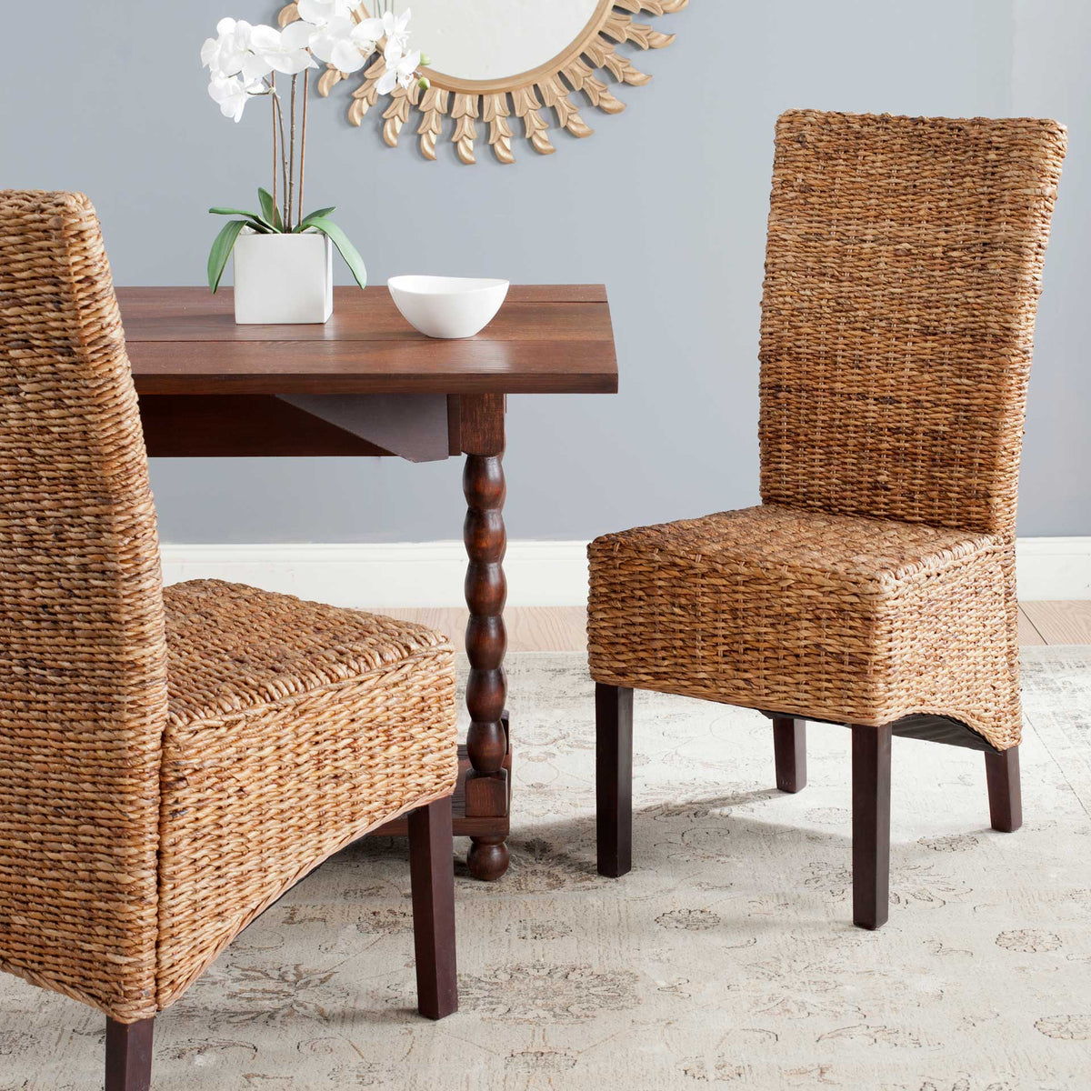 Woven rattan chairs add relaxed texture and rich wood accents around a dining table.