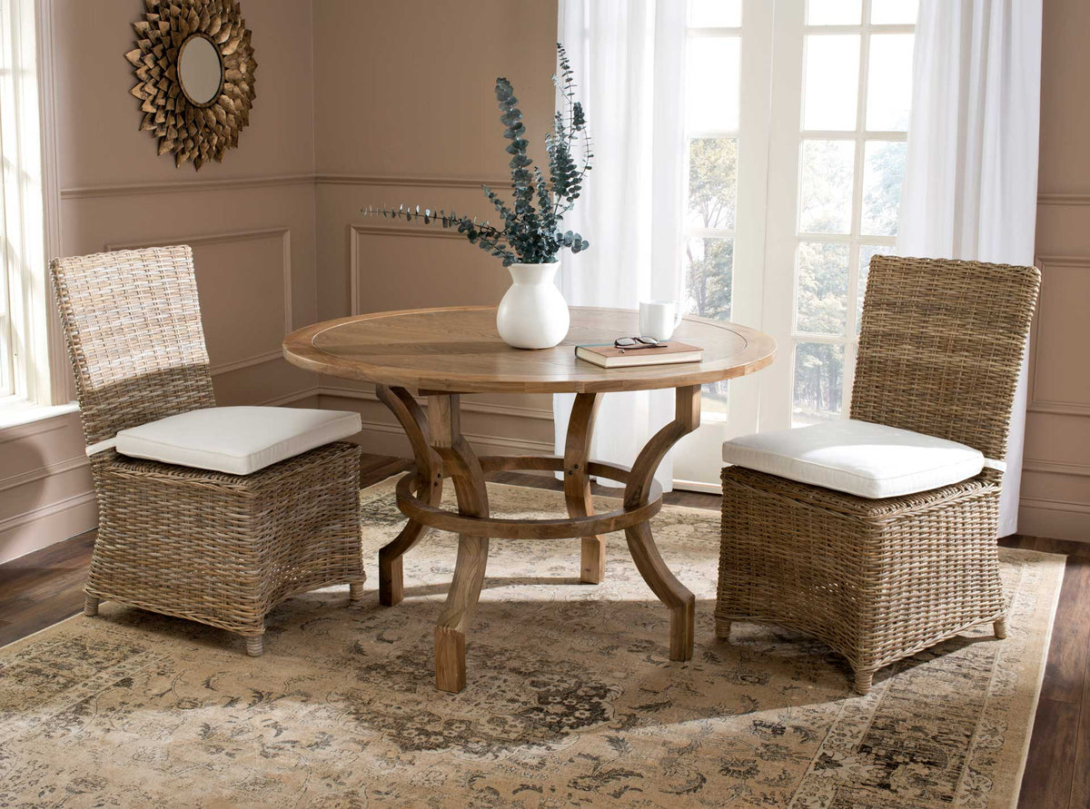 Two natural rattan dining chairs bring warm texture and white-cushioned comfort to the table.