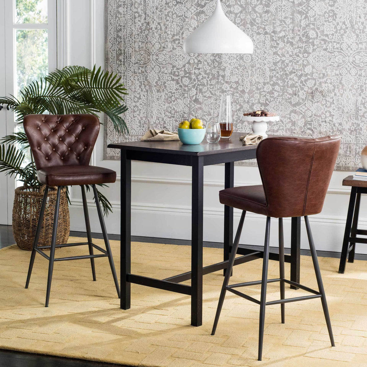 Burgundy bar stools reveal a tufted front and smooth back beside a high table.