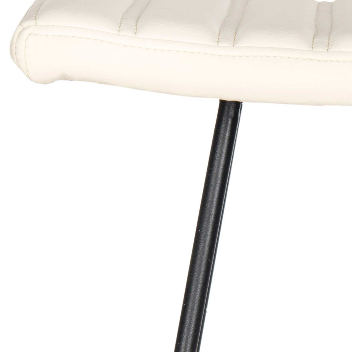 A narrow black metal leg meets the cream padded seat beneath its stitched edge.