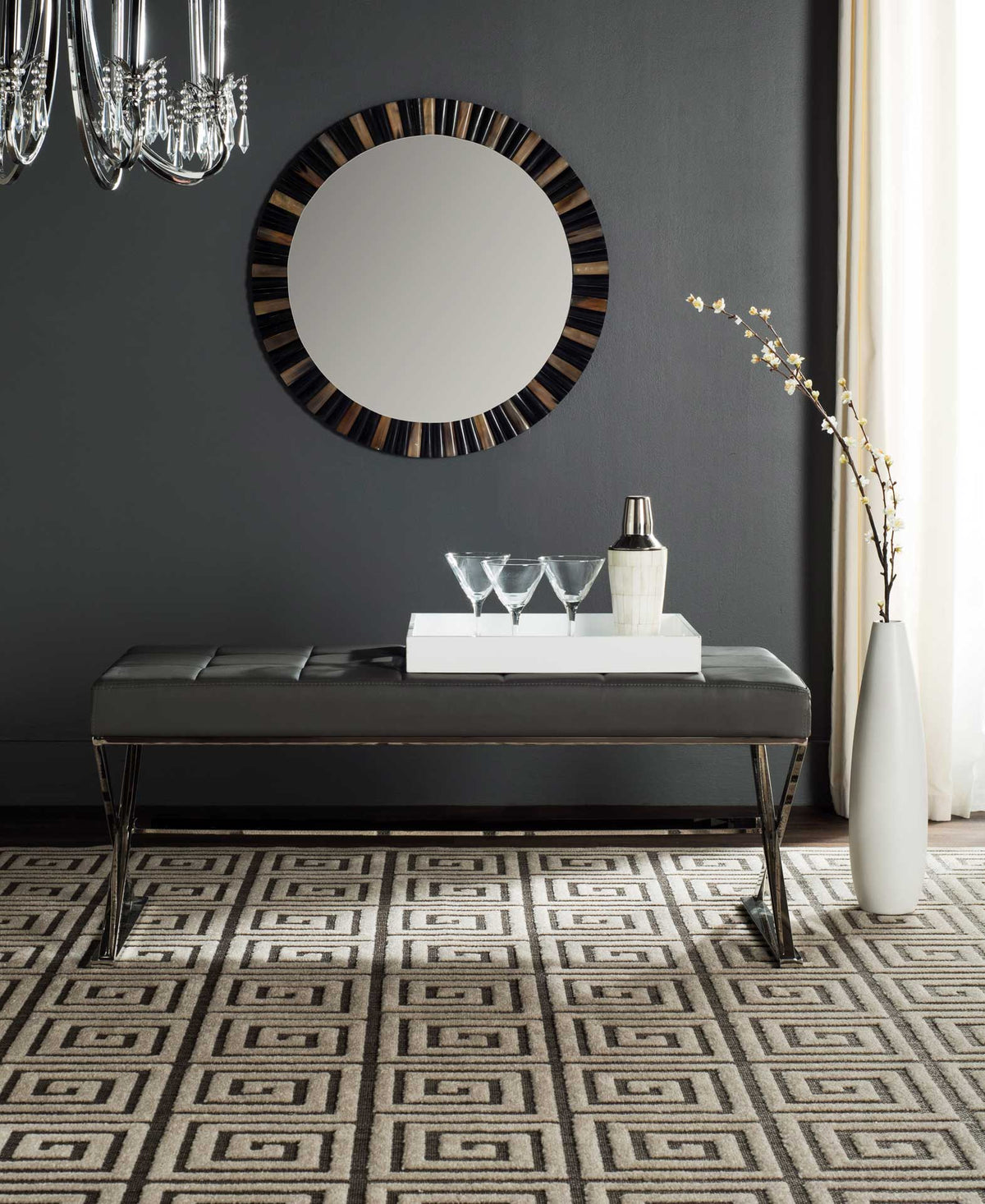 A gray upholstered bench with a tufted seat and polished X-shaped legs adds a refined touch.