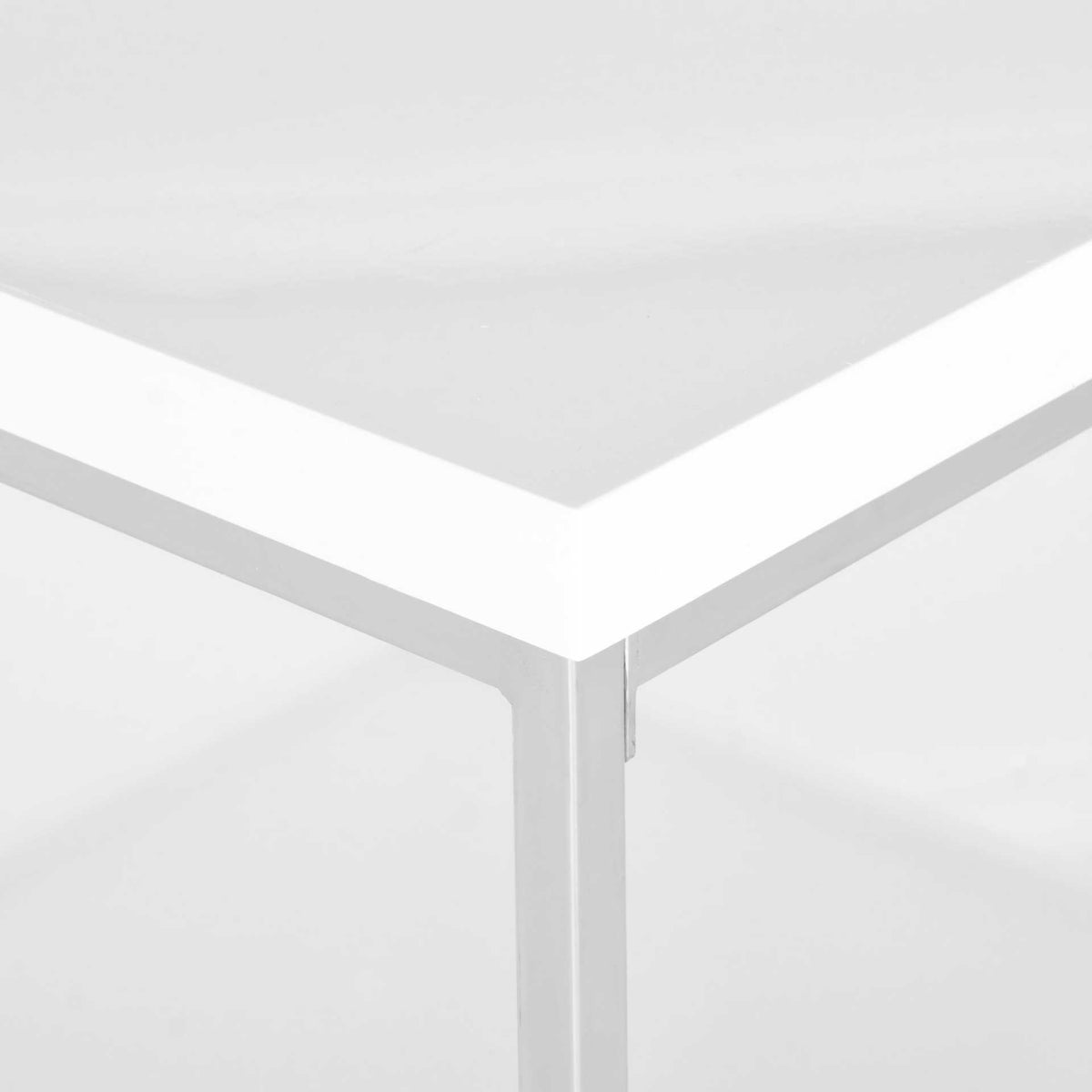 A crisp white tabletop meets polished chrome at the table's geometric corner