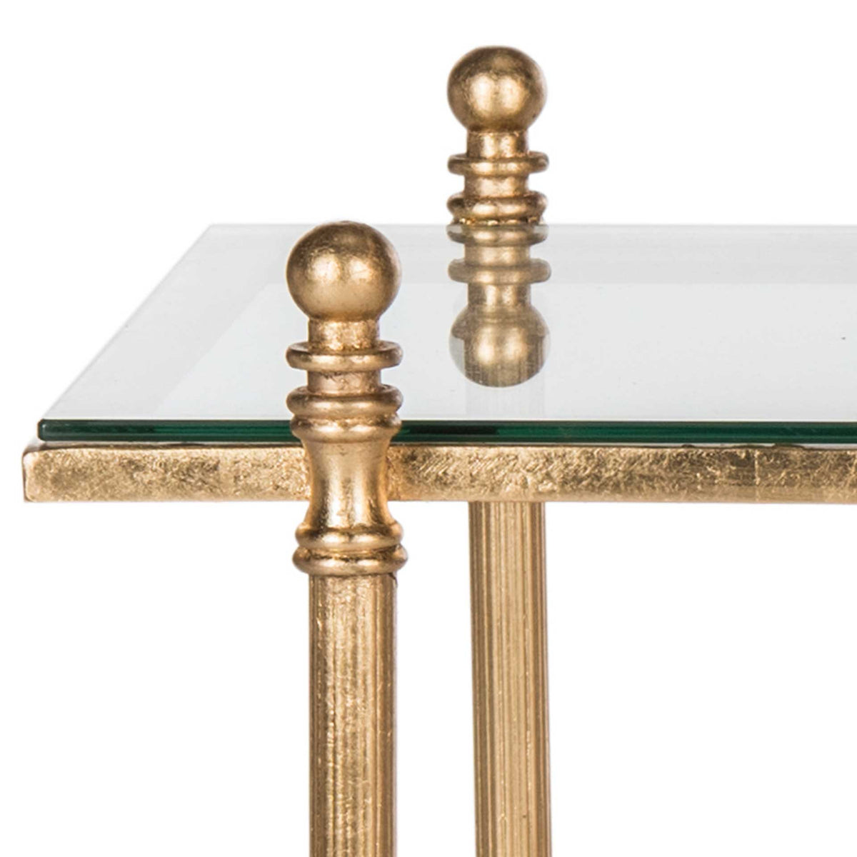Rounded finials crown textured gold iron legs beneath the clear glass tabletop