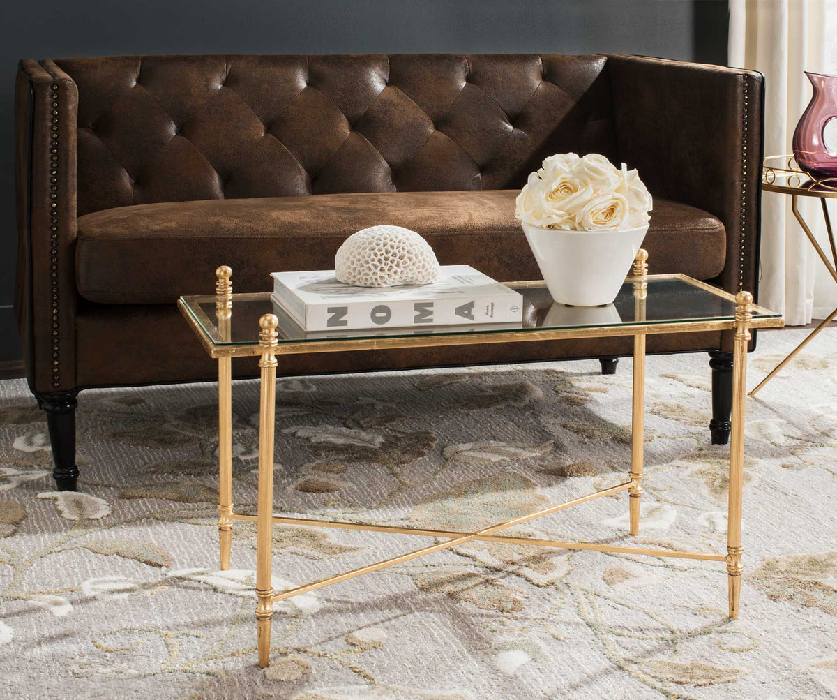 Slender gold legs and a clear glass top bring an airy touch to a cozy living room