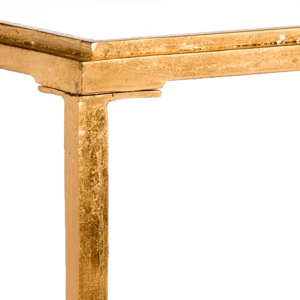 Stepped antique gold trim meets a slender leg beneath the glass tabletop