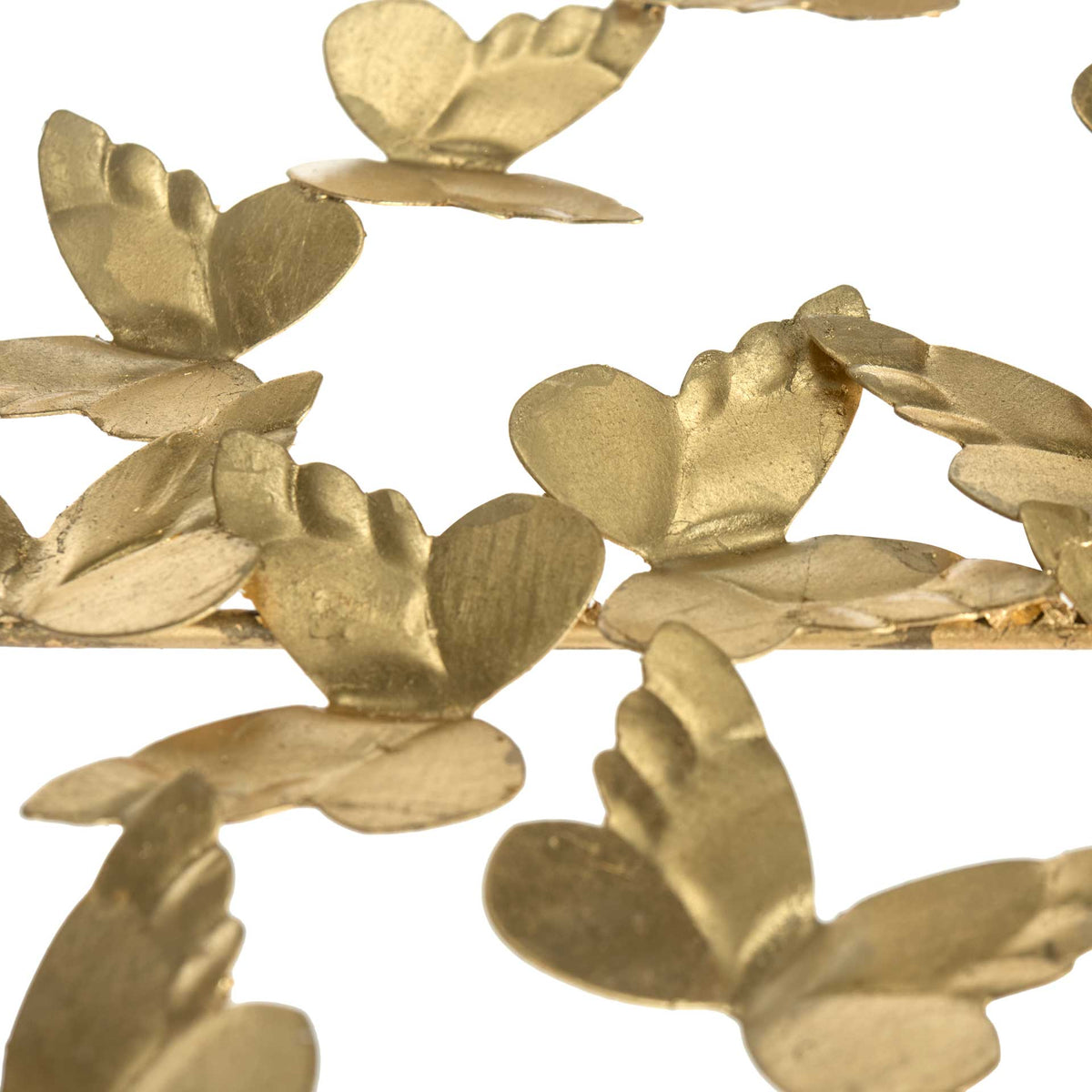 Dimensional gold butterfly wings add delicate, sculptural texture to the desk.