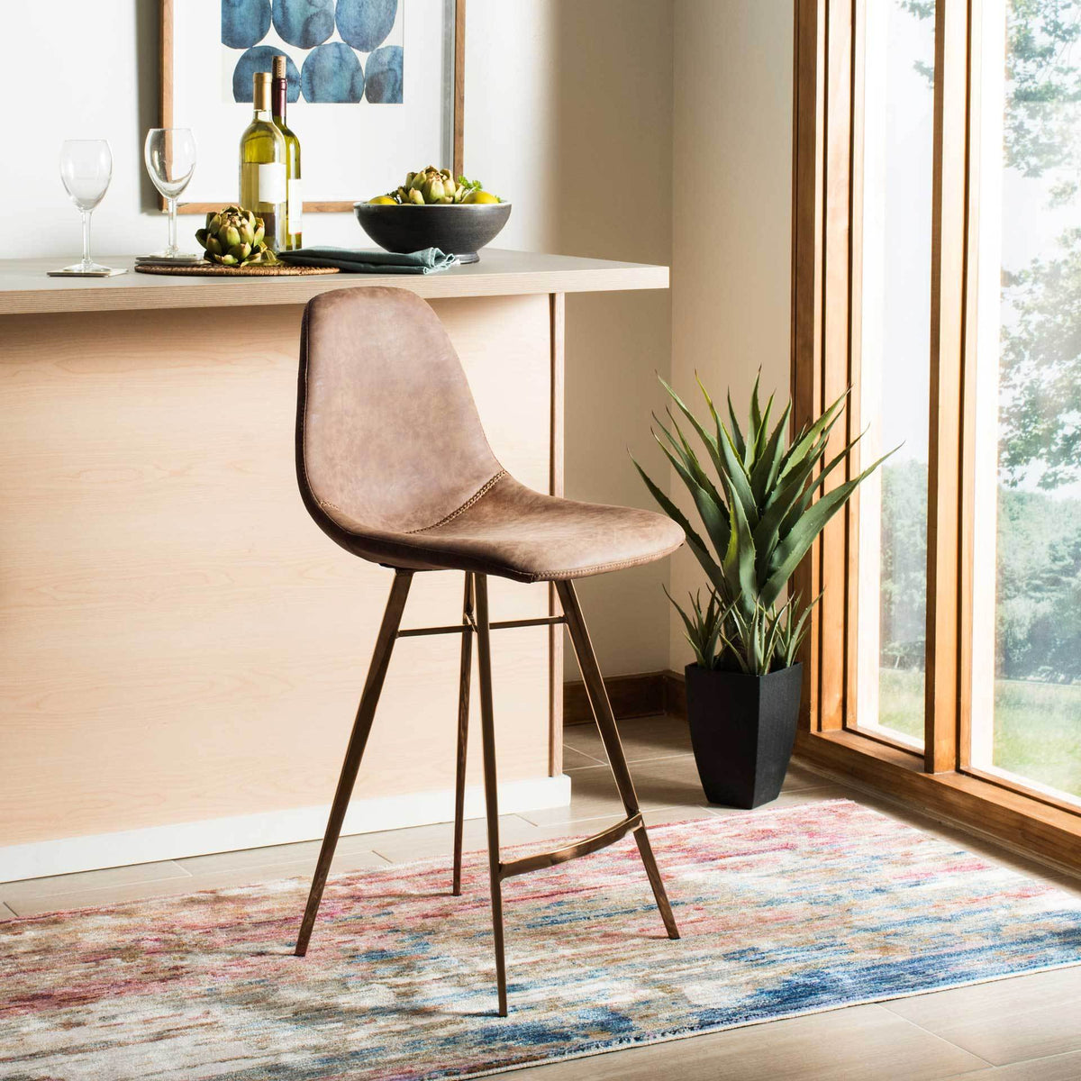 This brown faux leather counter stool pairs a rounded seat with sleek copper-toned legs.