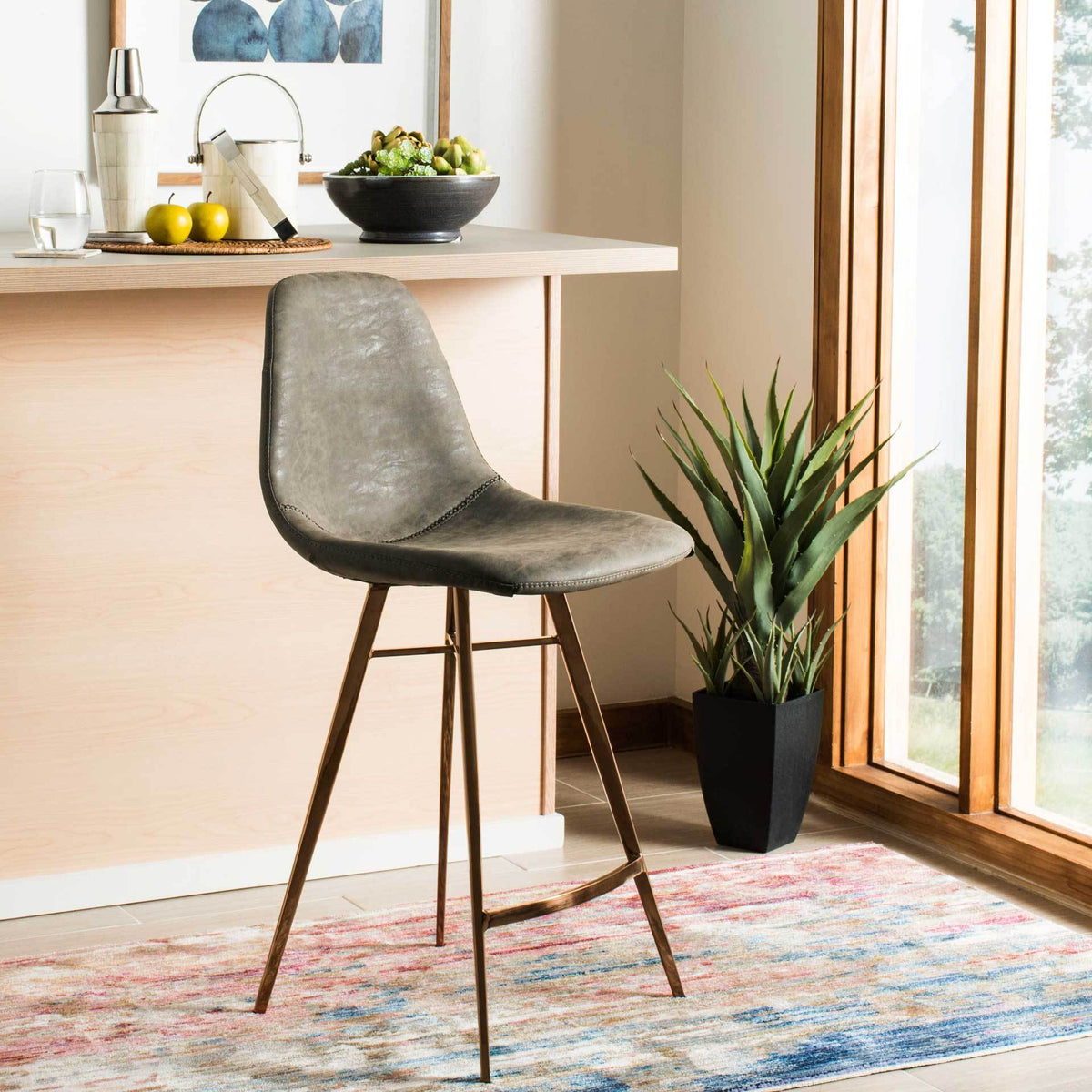 Taupe faux leather softens this counter stool's shape above slim copper-finished legs.
