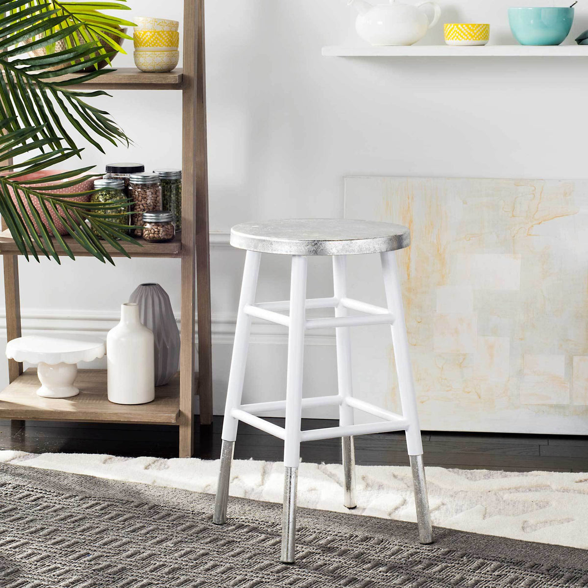 A white counter stool brings a light, airy feel with its silver seat and silver-tipped feet.