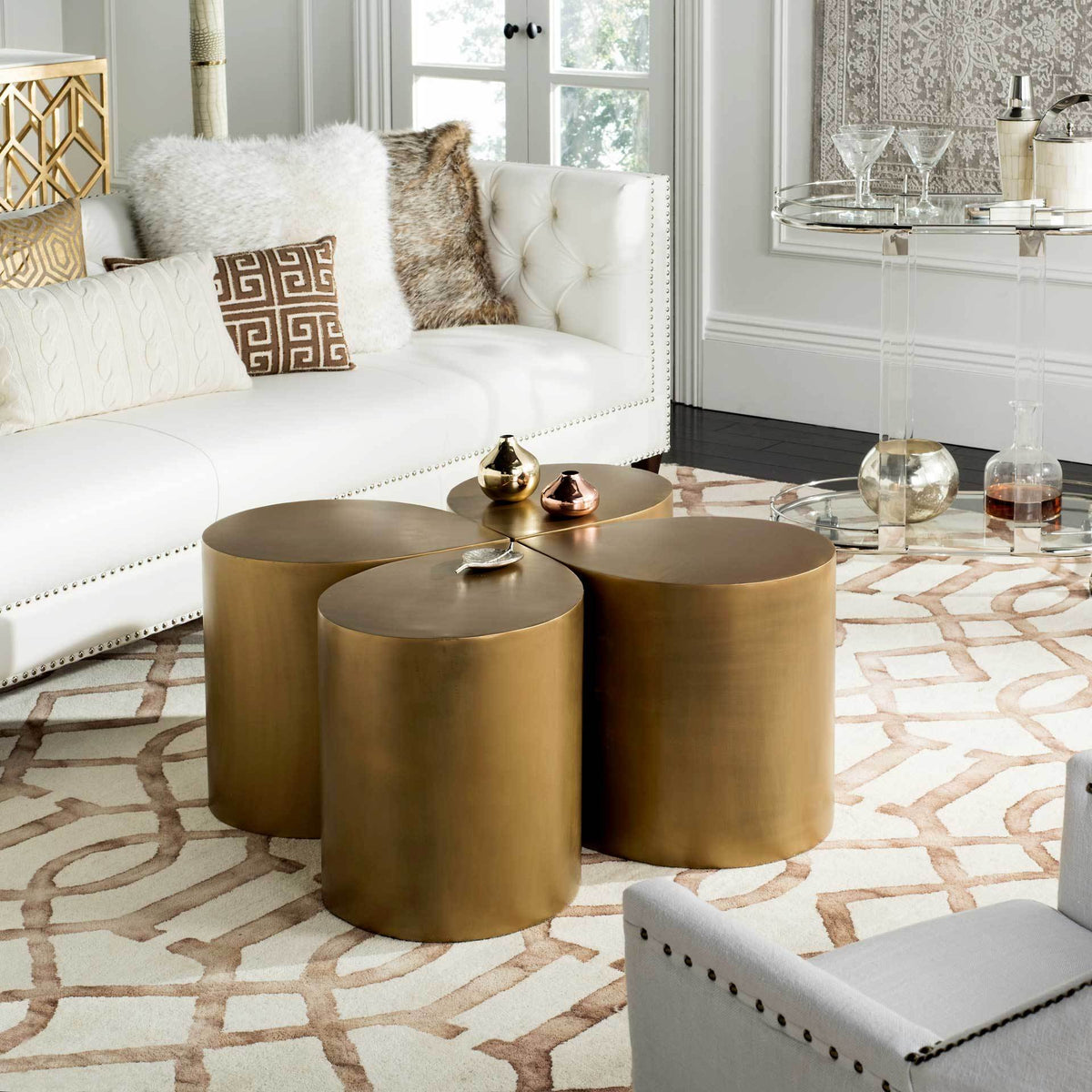 Four rounded sections gather into a low coffee table with a rich antique brass sheen.