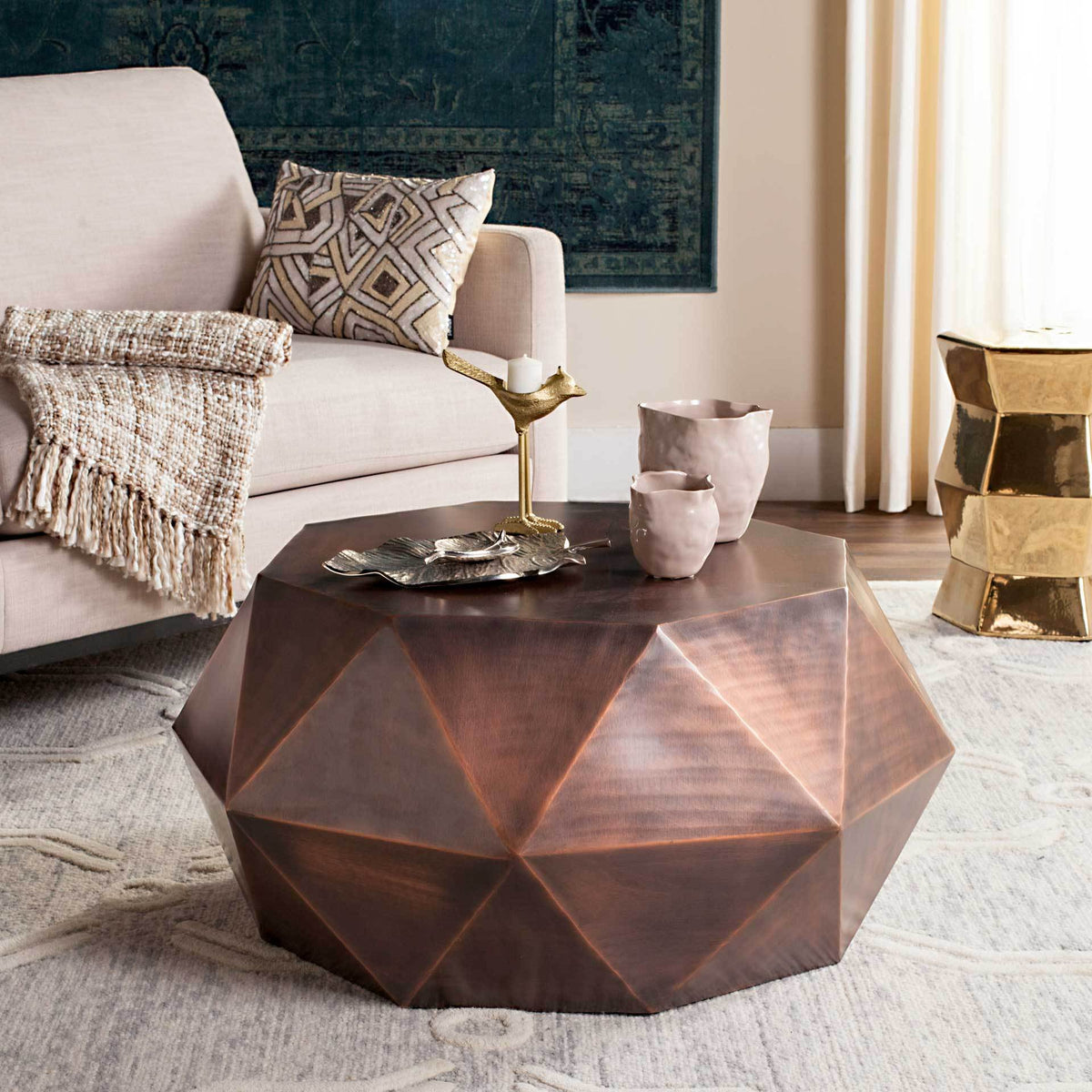 Warm copper coffee table adds a sculptural silhouette and rich metallic finish to a seating area
