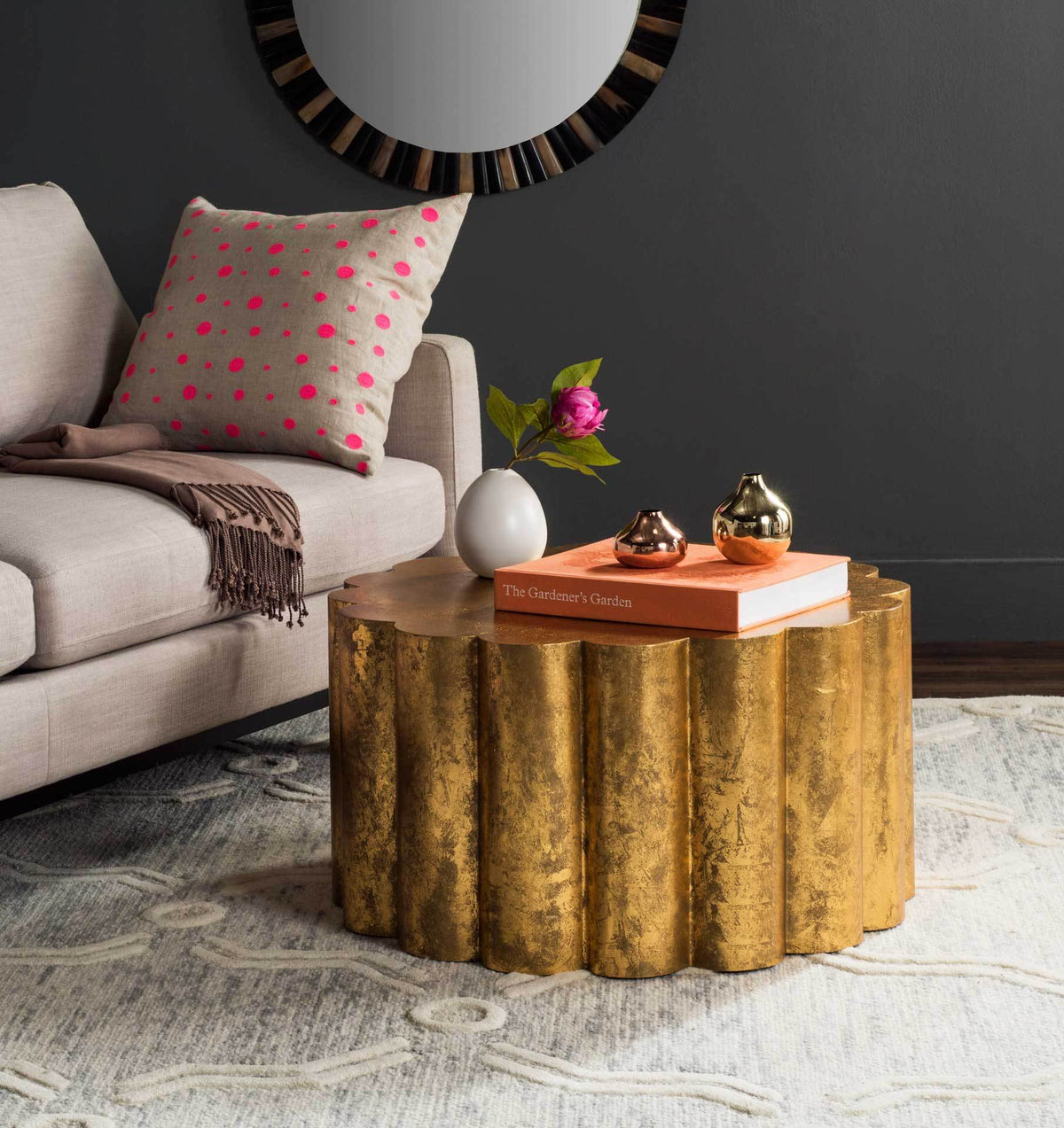 Round gold coffee table with a fluted drum base and a wide top for books and decor