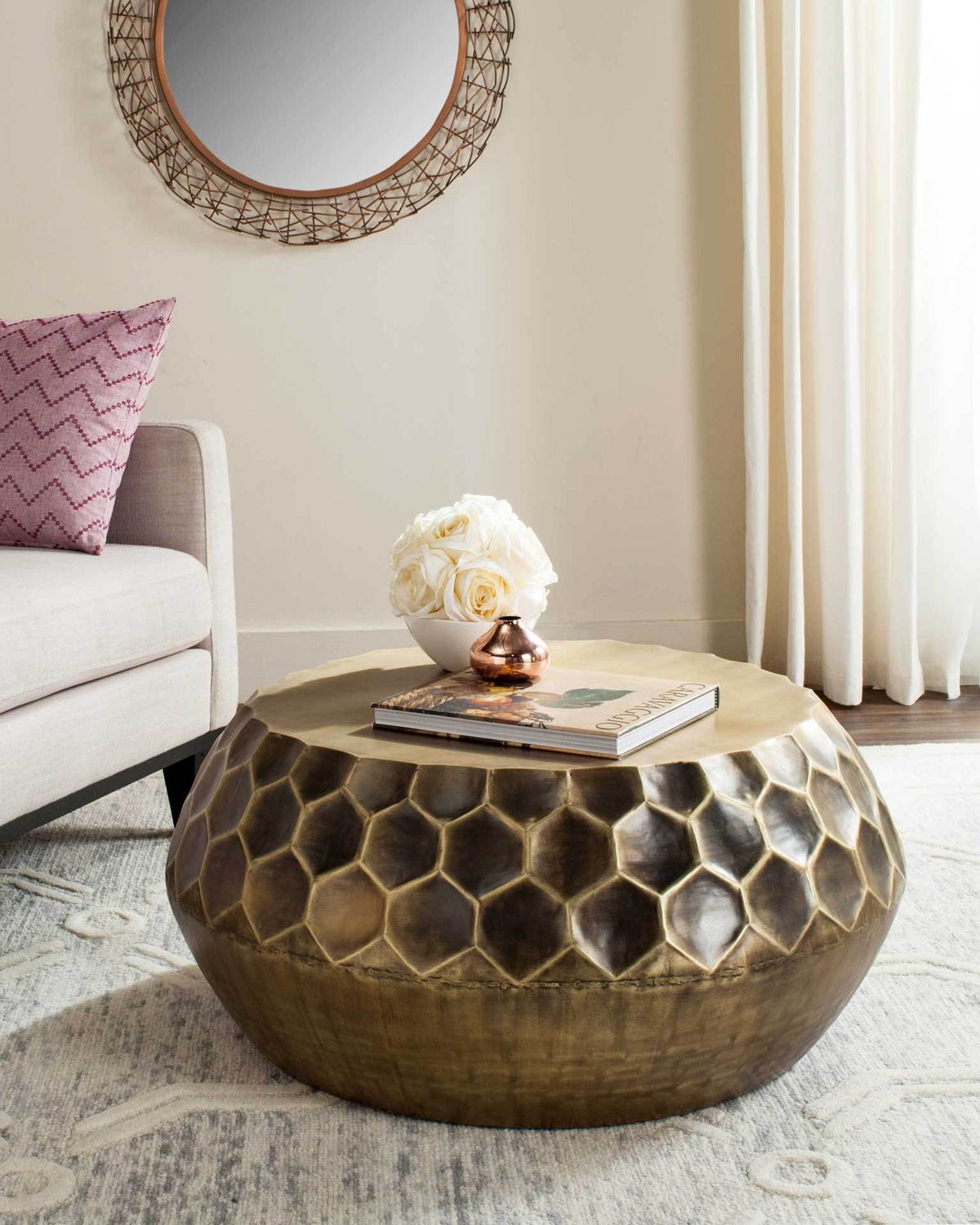 Warm antique brass coffee table adds honeycomb texture and sculptural curves to a cozy seating area