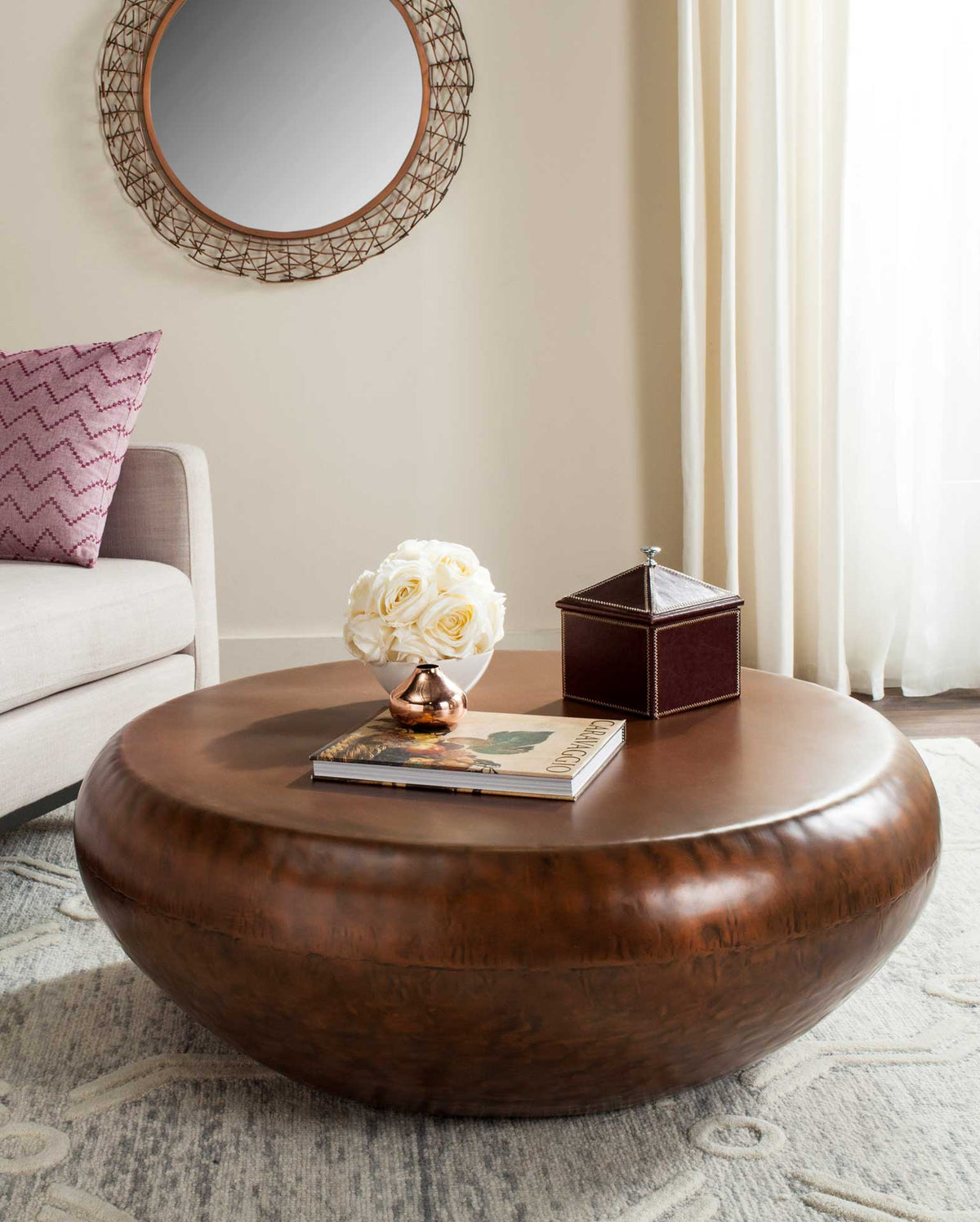 Broad copper-finished tabletop and low, rounded base add warmth to the living room