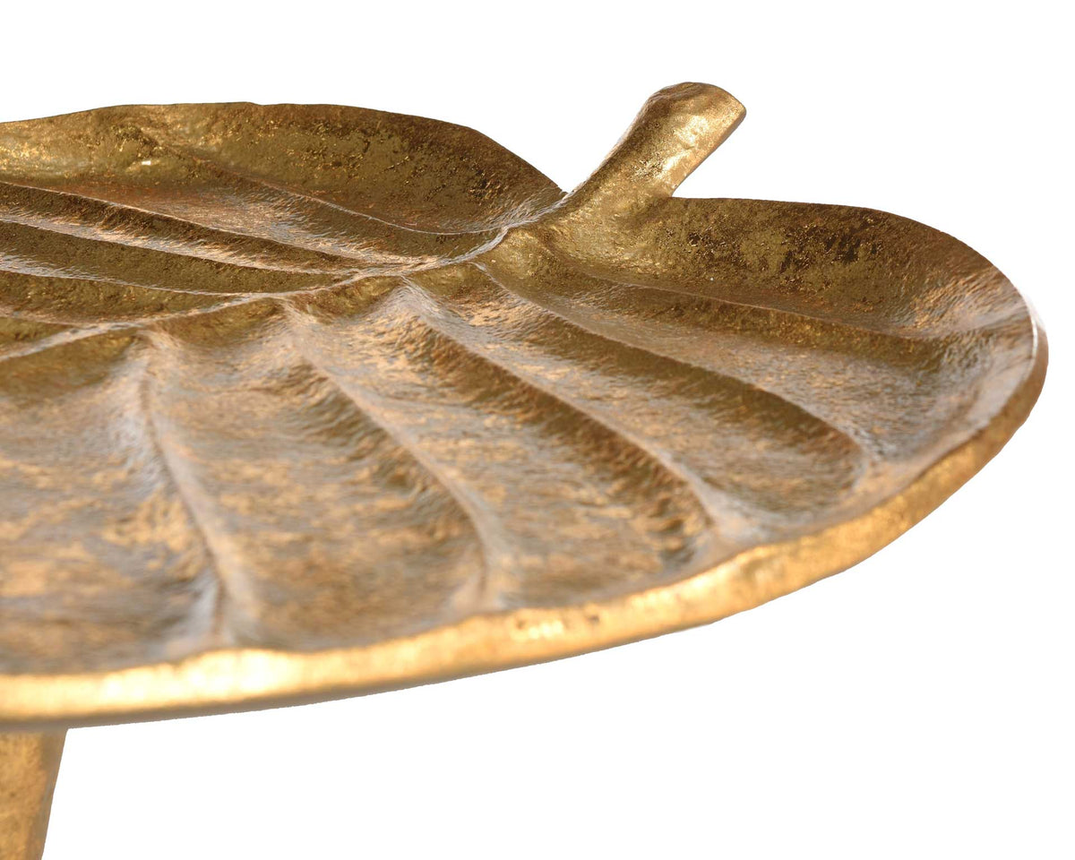 Sculpted veins sweep toward a short stem on the gleaming gold leaf tabletop.