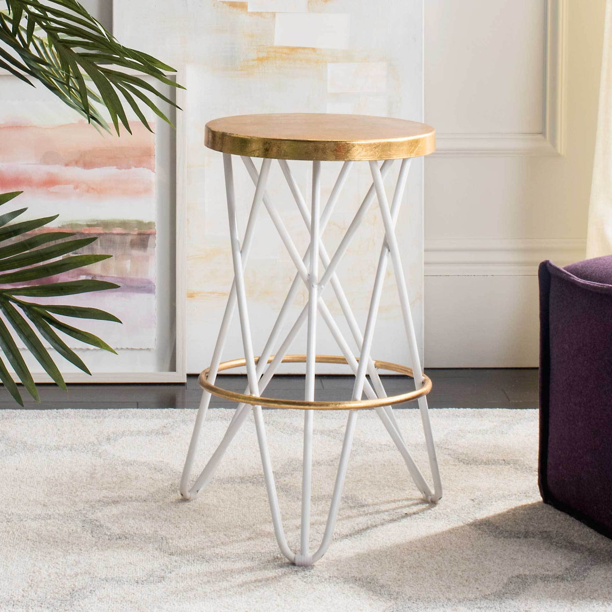 This backless counter stool pairs a bright white sculptural base with a lustrous gold seat.