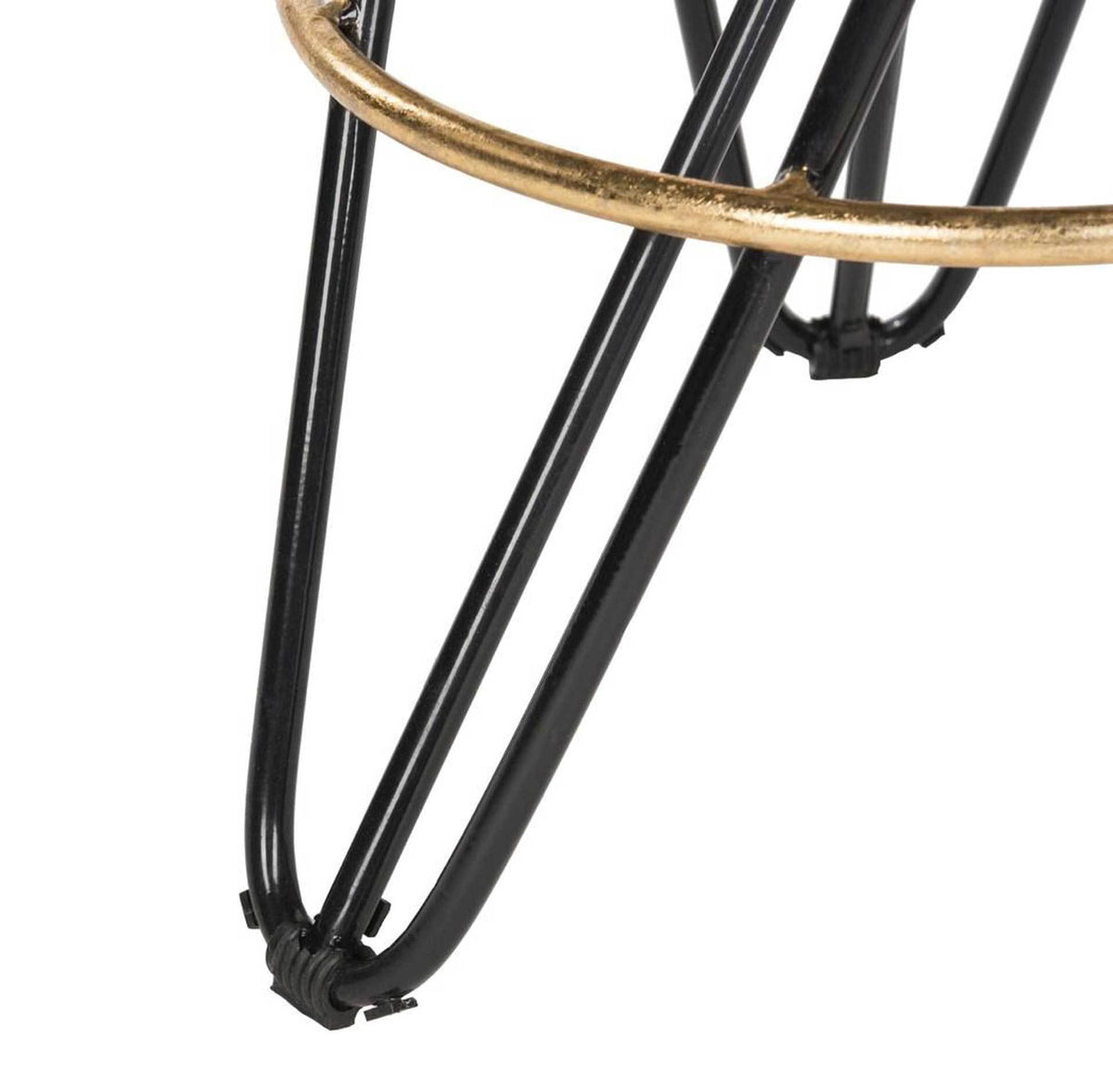 Black iron hairpin feet curve beneath slim crossed legs and a gleaming gold ring footrest.