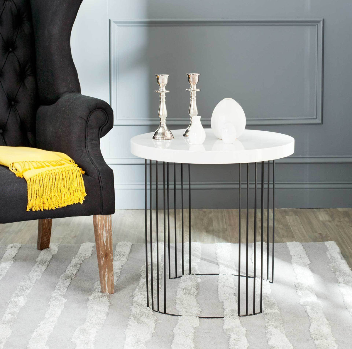 A bright white tabletop and fine black legs add a polished accent beside a dark upholstered chair