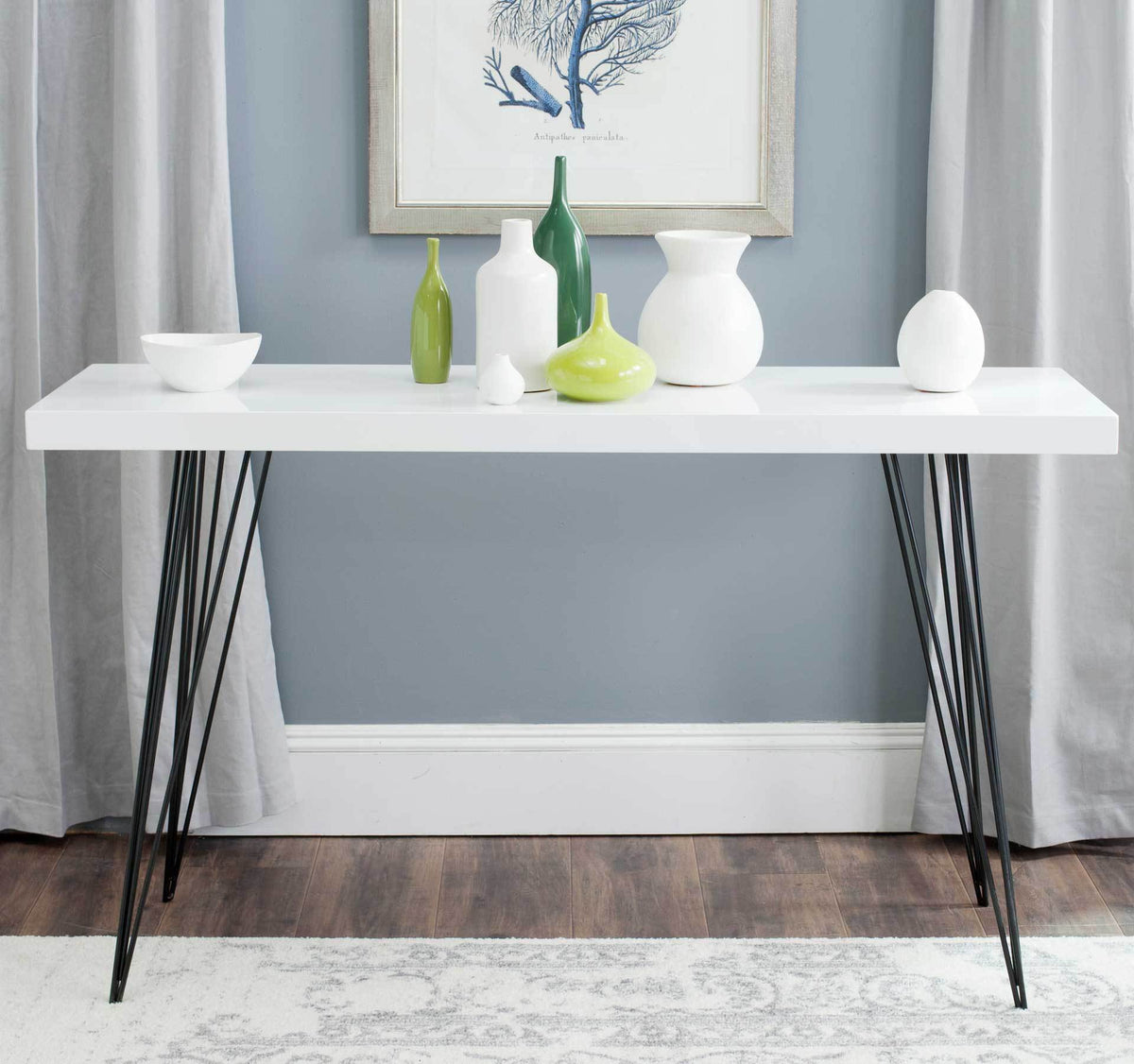 White console table creates a bright display for colorful vases atop delicate black iron legs.