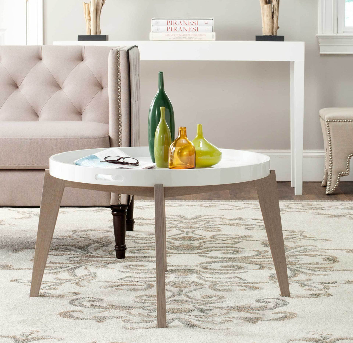 A round white tray displays colorful vases above a splayed gray-washed wood base