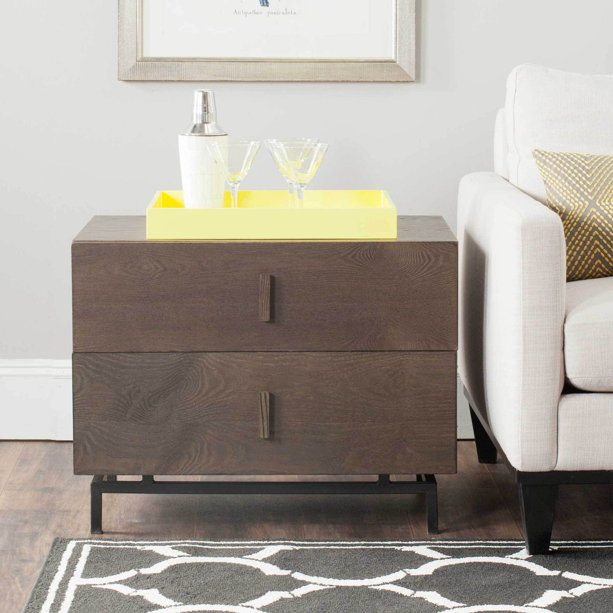 Dark brown two-drawer cabinet brings warm wood grain and black metal legs beside a sofa