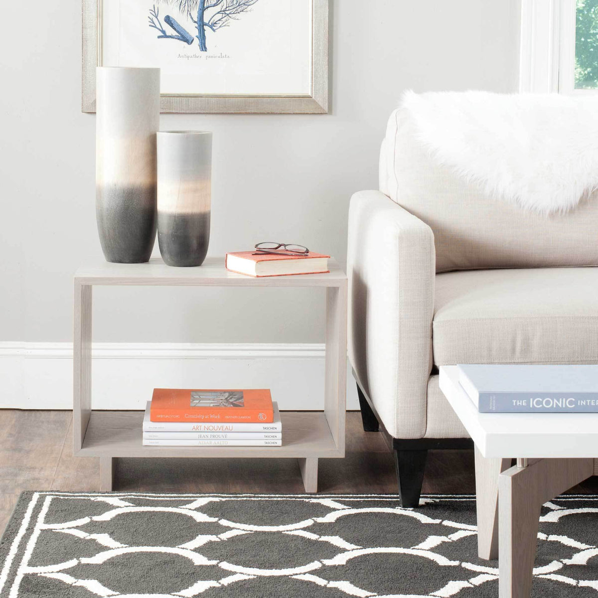 A low open stand keeps books and decorative accents within easy reach beside a sofa