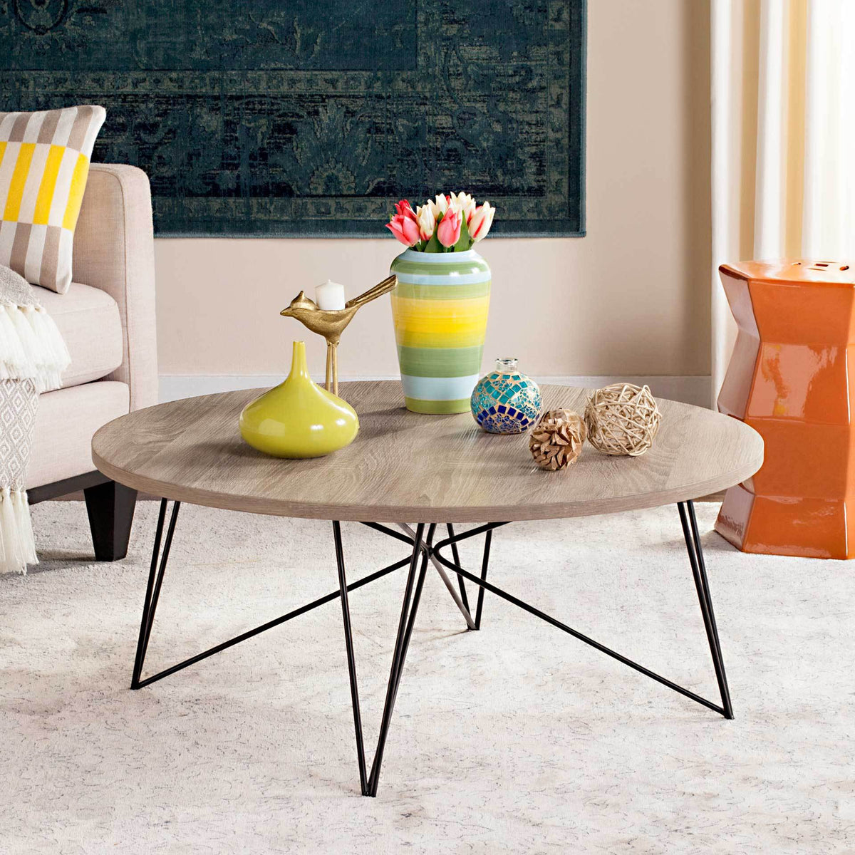 Warm wood-grain tabletop and airy, intersecting iron legs give this round coffee table modern appeal