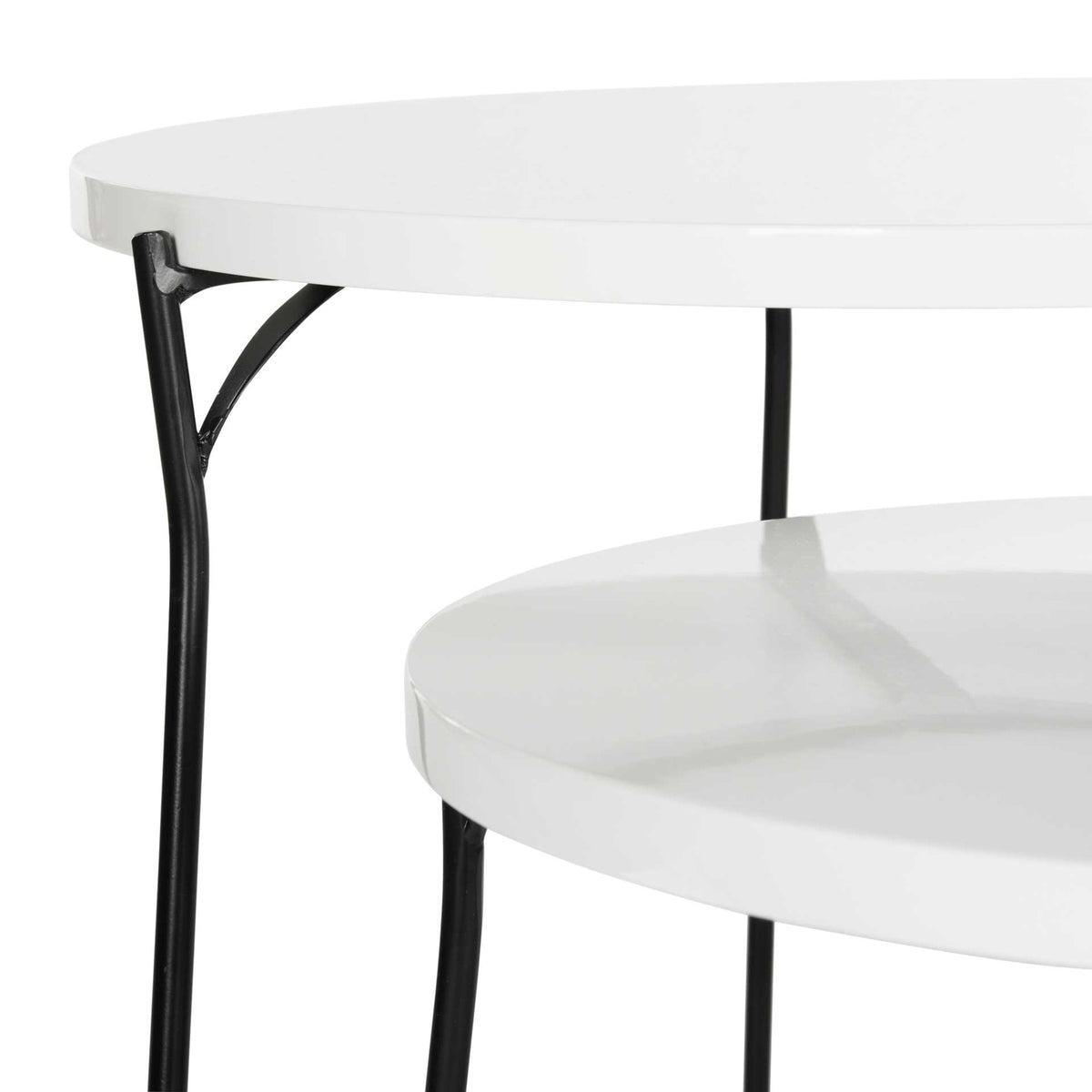 Curved black iron braces support the white tabletop edges of the nesting tables.