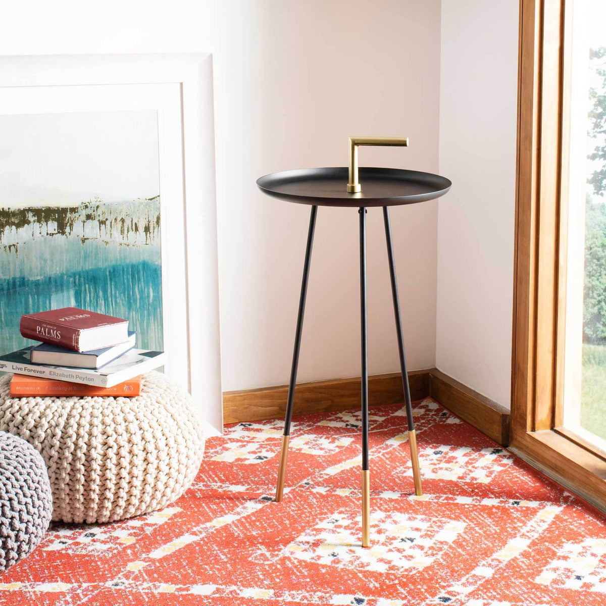 Black and gold metal side table adds a sleek accent beside a cozy reading nook