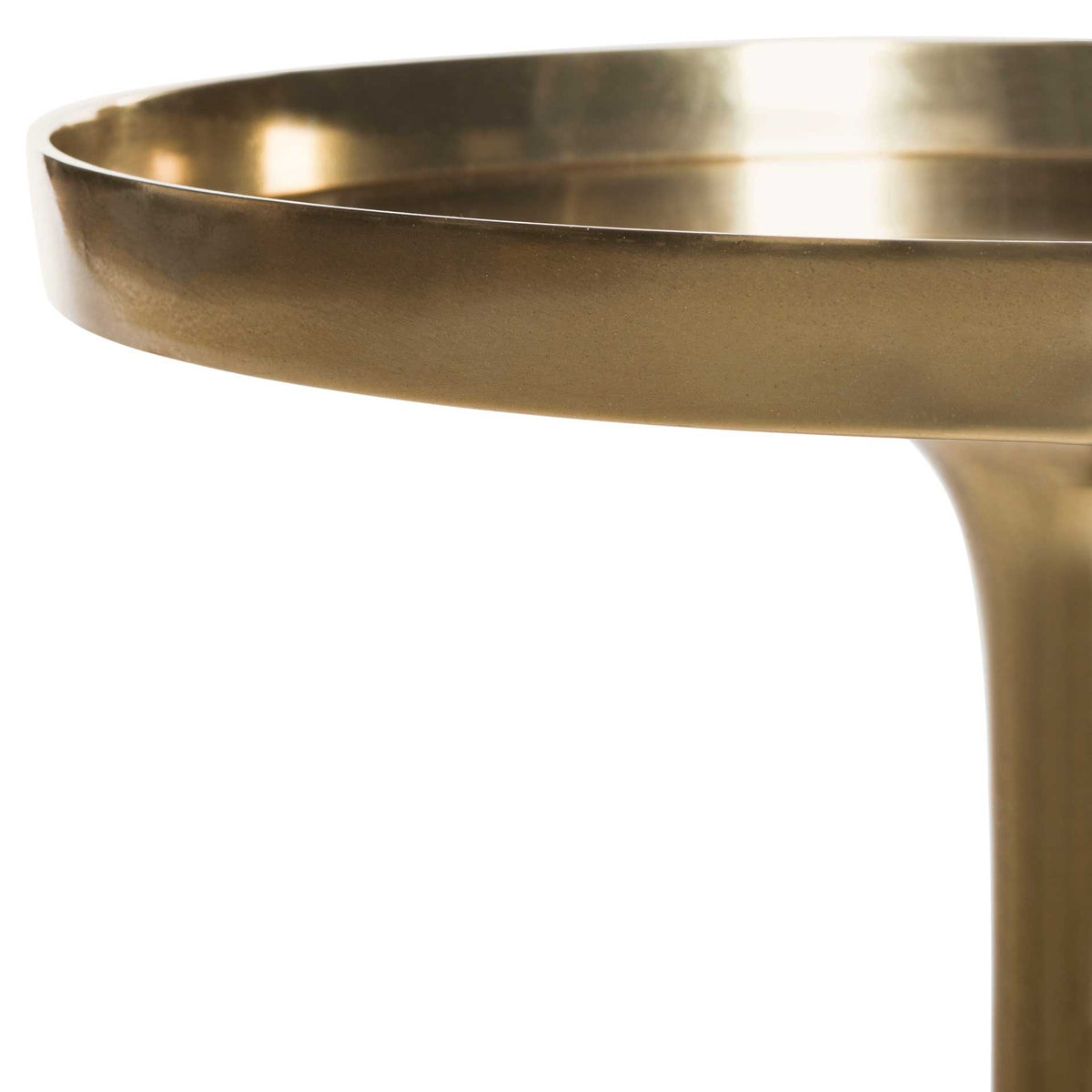 Subtle texture softens the sheen of the antique brass finish along the rounded tabletop edge.