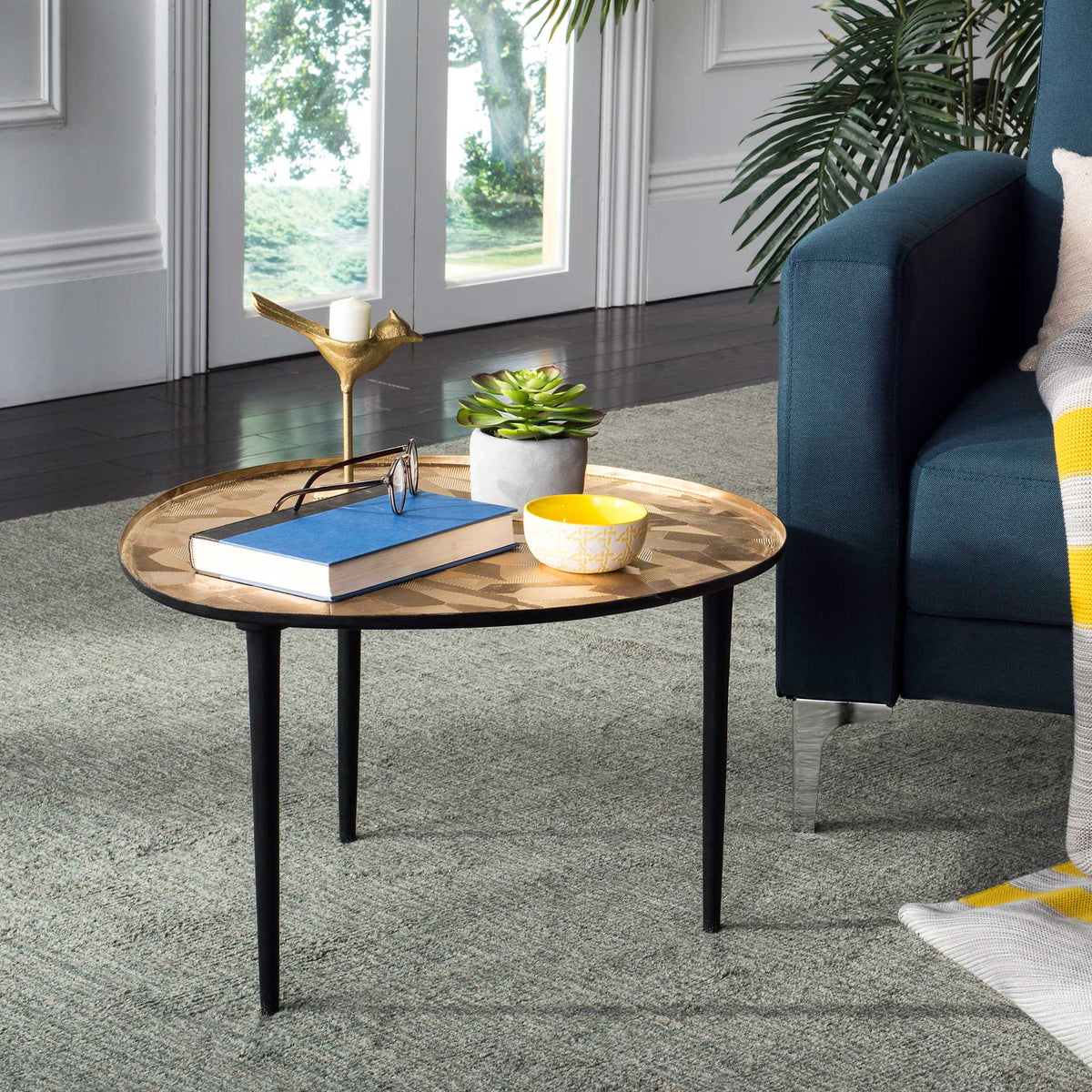 Textured oval side table with slender black legs adds warmth beside a sofa