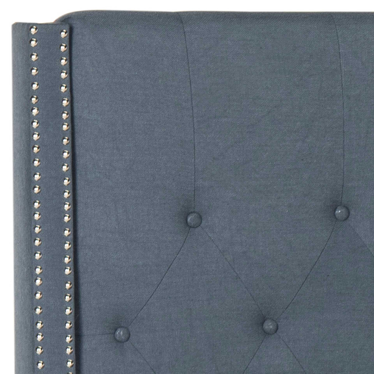 Deep navy fabric and diamond button tufting meet twin rows of silver nailheads on the headboard.