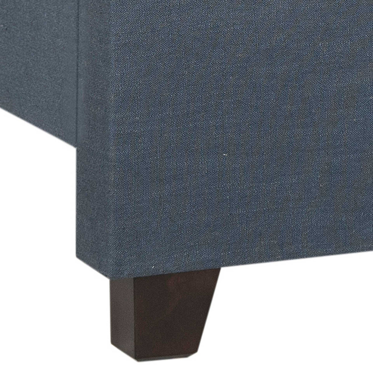 An espresso-finished wood foot grounds the navy linen-covered bed frame.