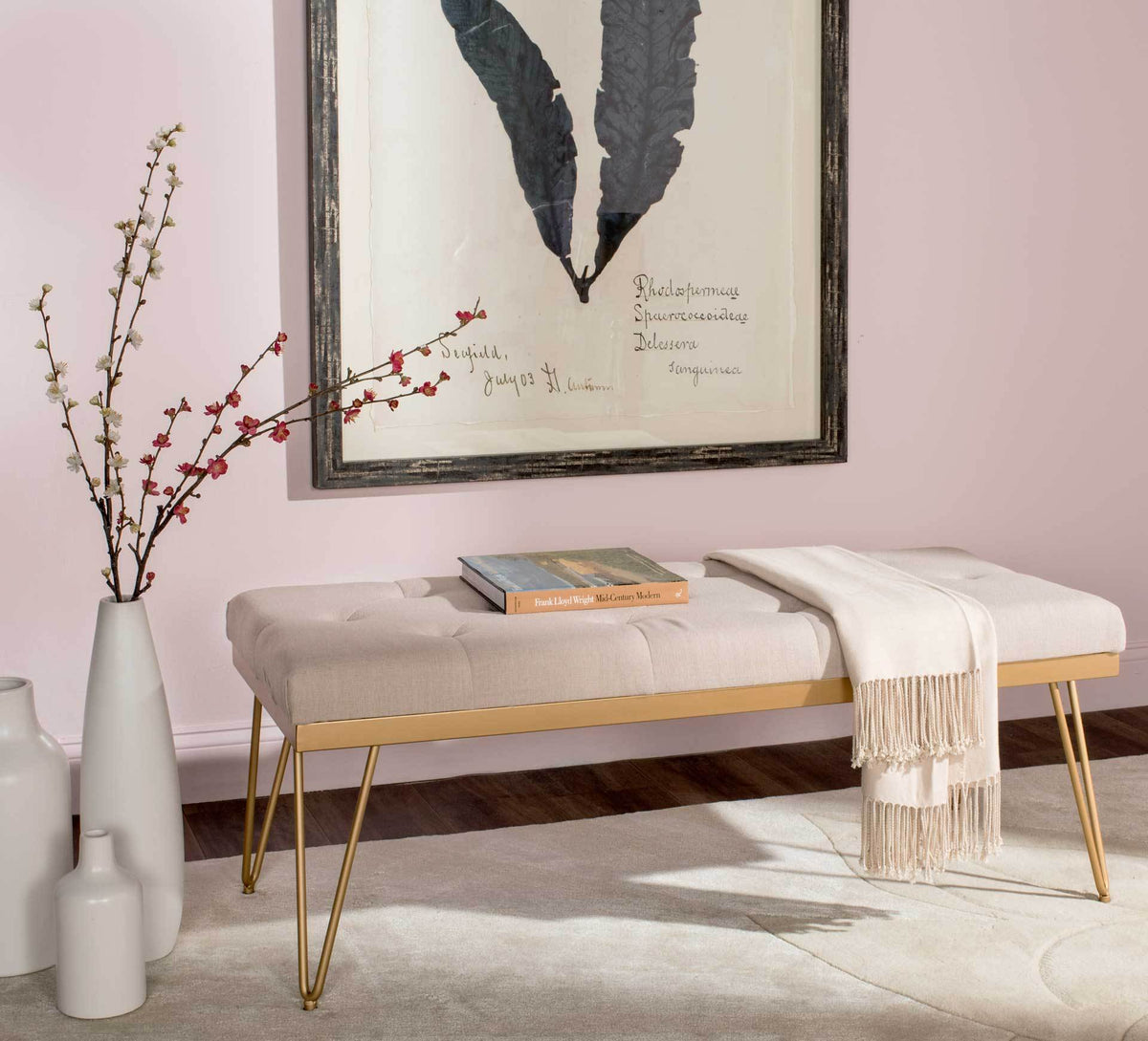 Generously cushioned beige bench brings extra seating with gold trim and elegant hairpin legs.