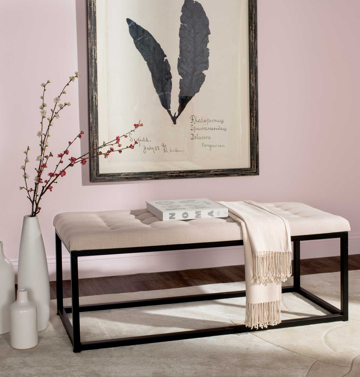 Soft beige upholstery adds warmth to a streamlined bench with an open black frame.