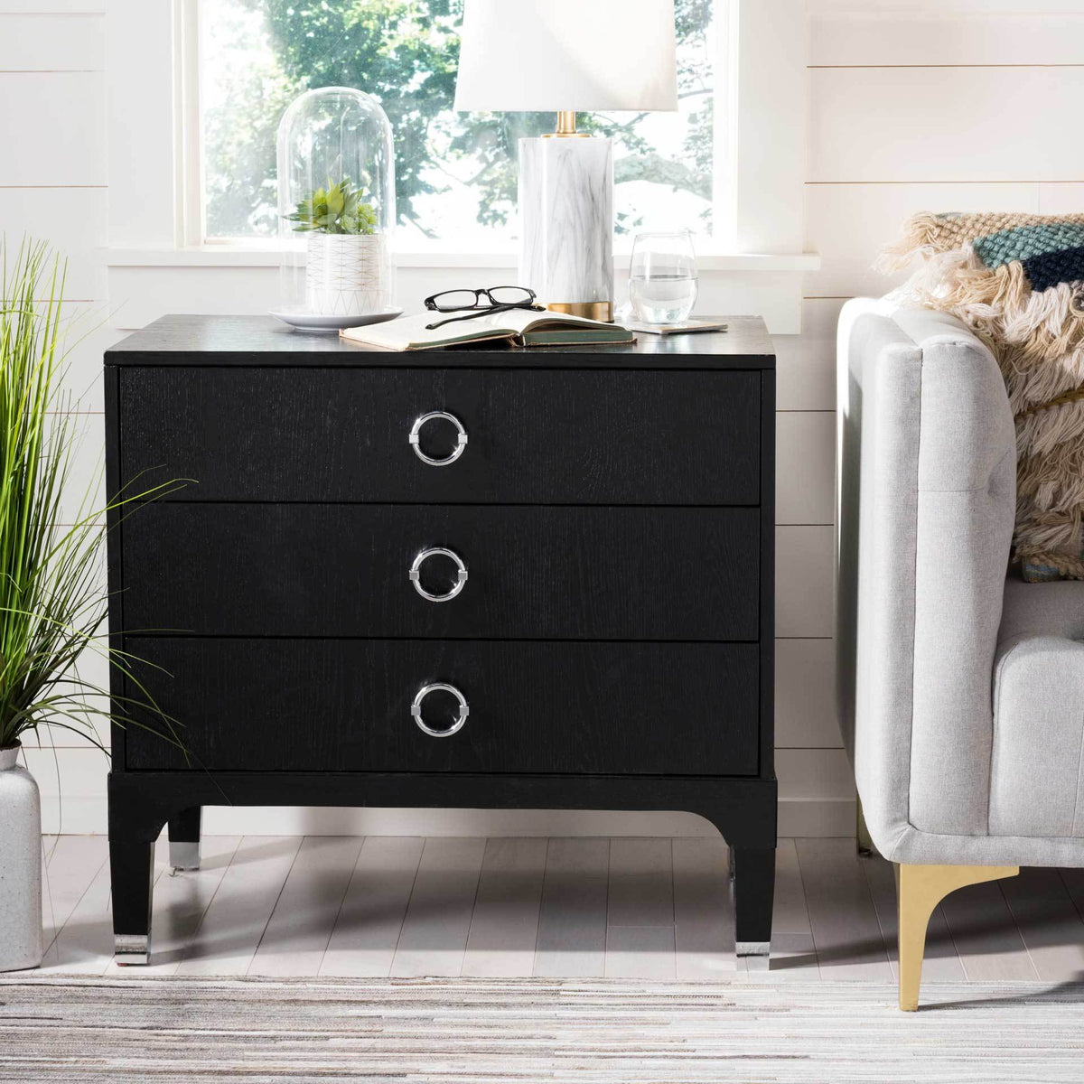 Silver ring pulls lend a polished accent to this black three-drawer nightstand with tapered legs