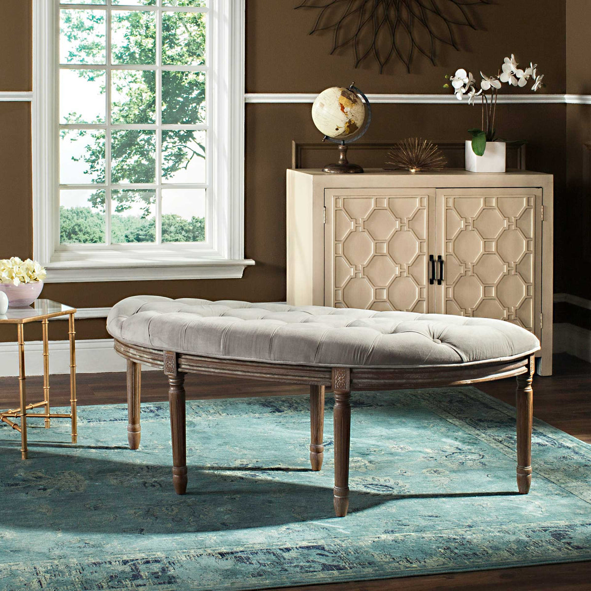 Gray velvet upholstery and rustic wood accents give the semicircular bench classic character
