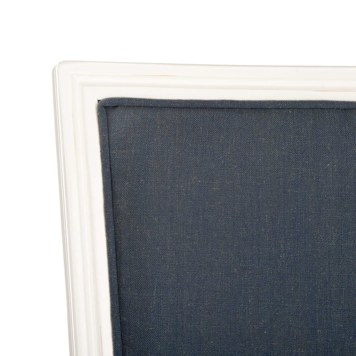 Textured navy linen fills a softly grooved distressed white wood backrest frame.