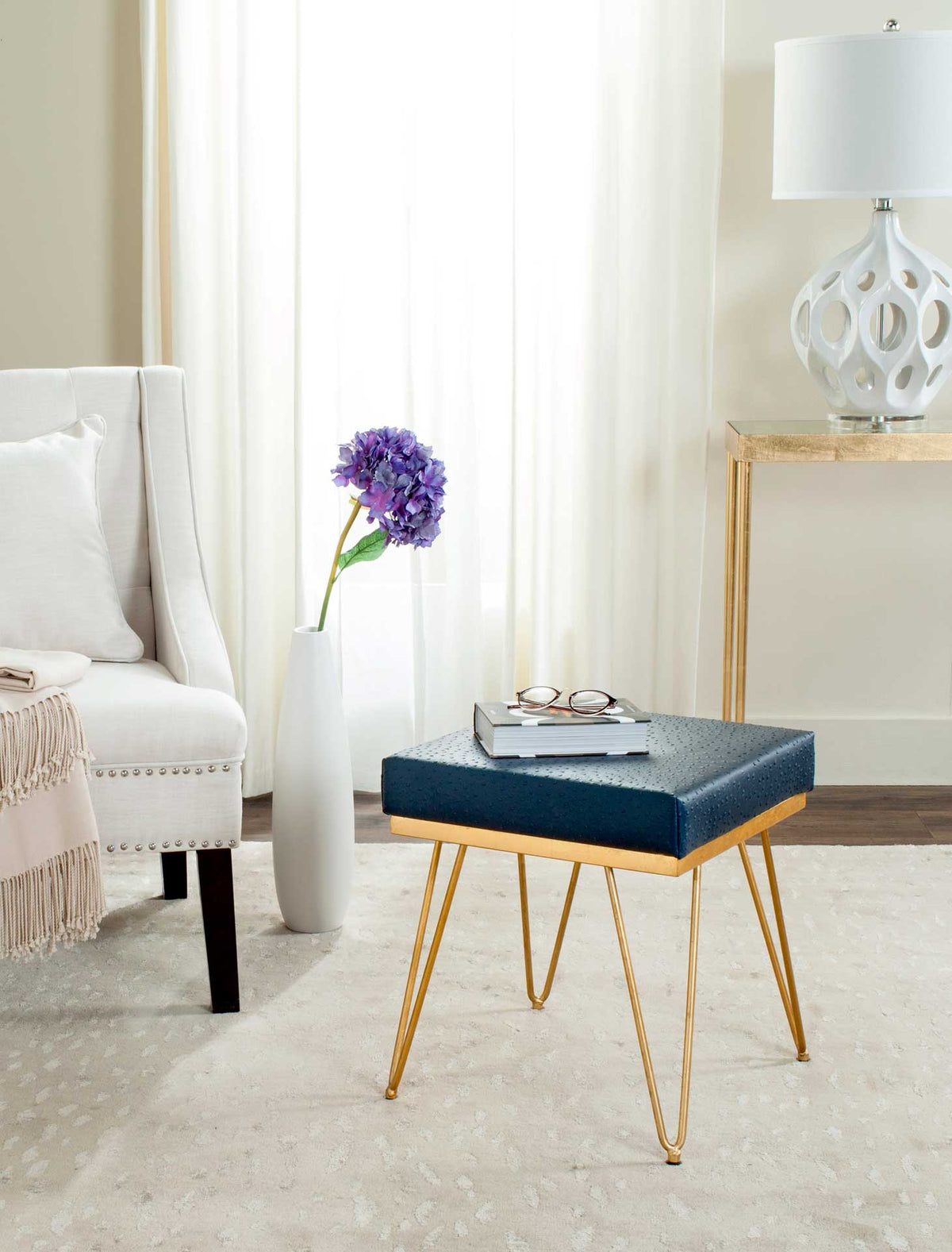Navy square bench adds rich color and gleaming gold-tone accents beside a sofa