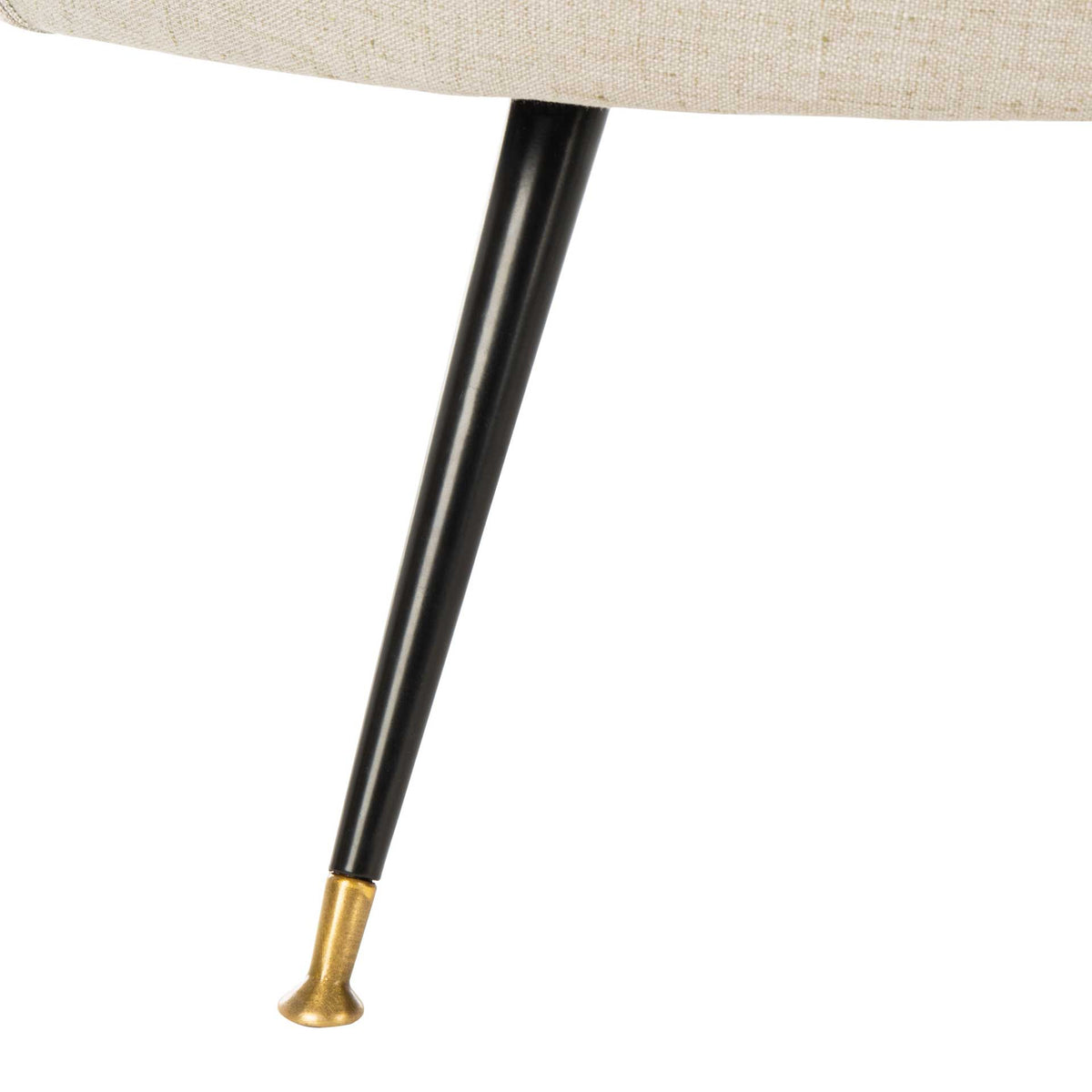 A slender black metal leg finishes in a gleaming gold cap beneath the light gray linen upholstery.