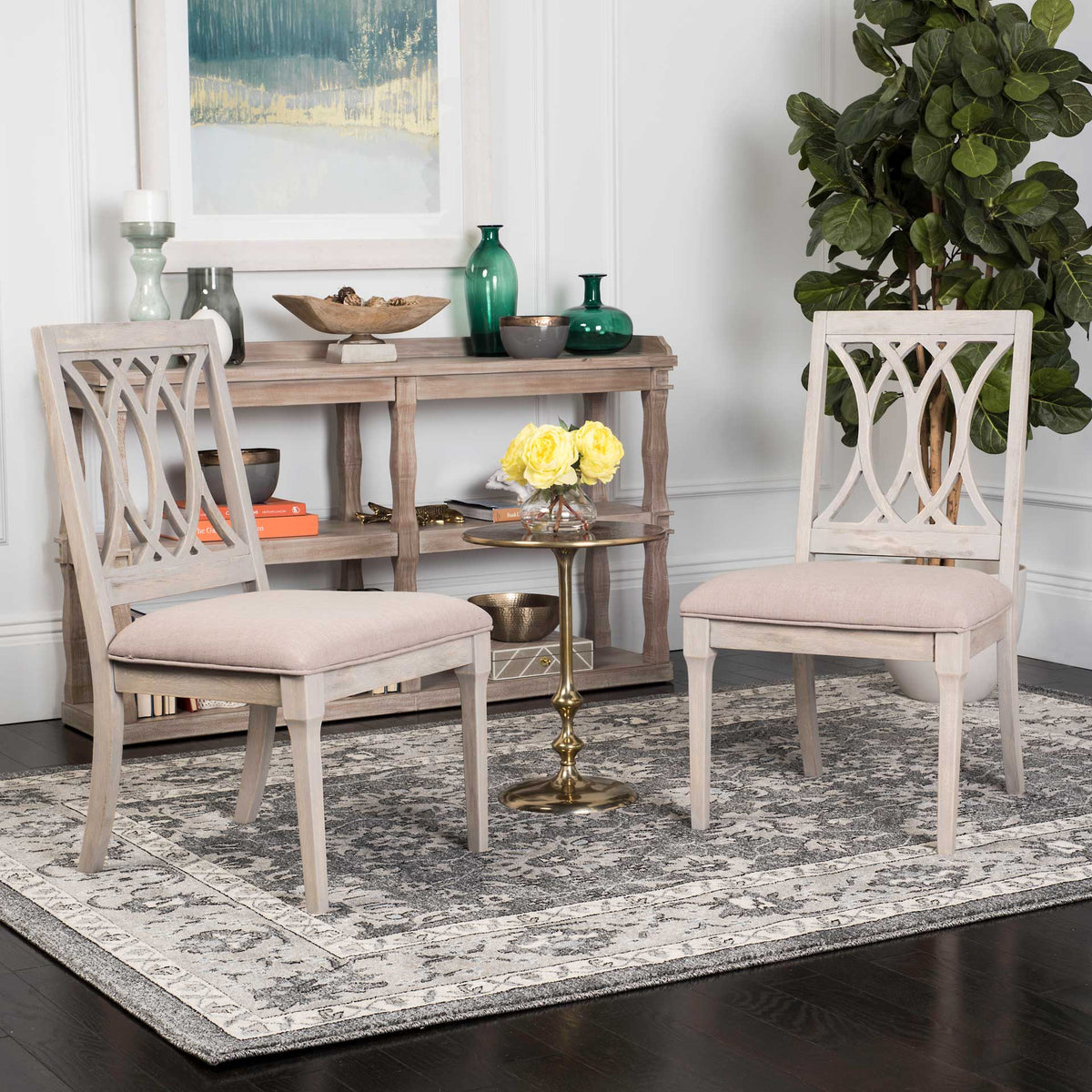 Two pale wood chairs with patterned open backs and taupe seats add warmth to a cozy interior