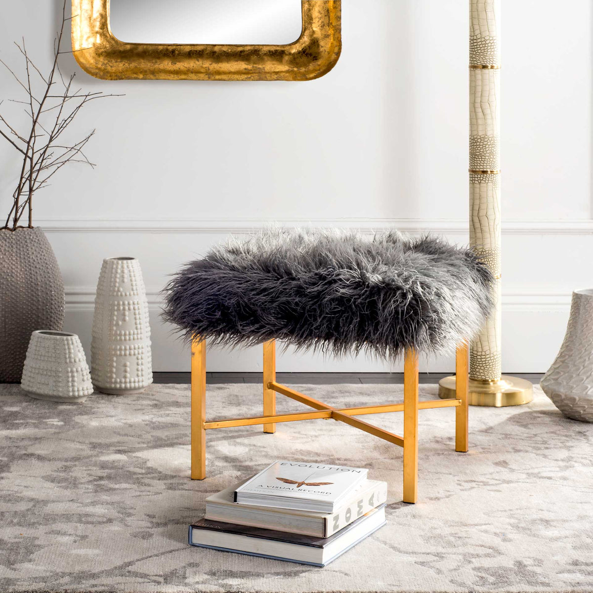 A plush gray faux sheepskin seat and slender gold X-braces bring texture and shine to the space.