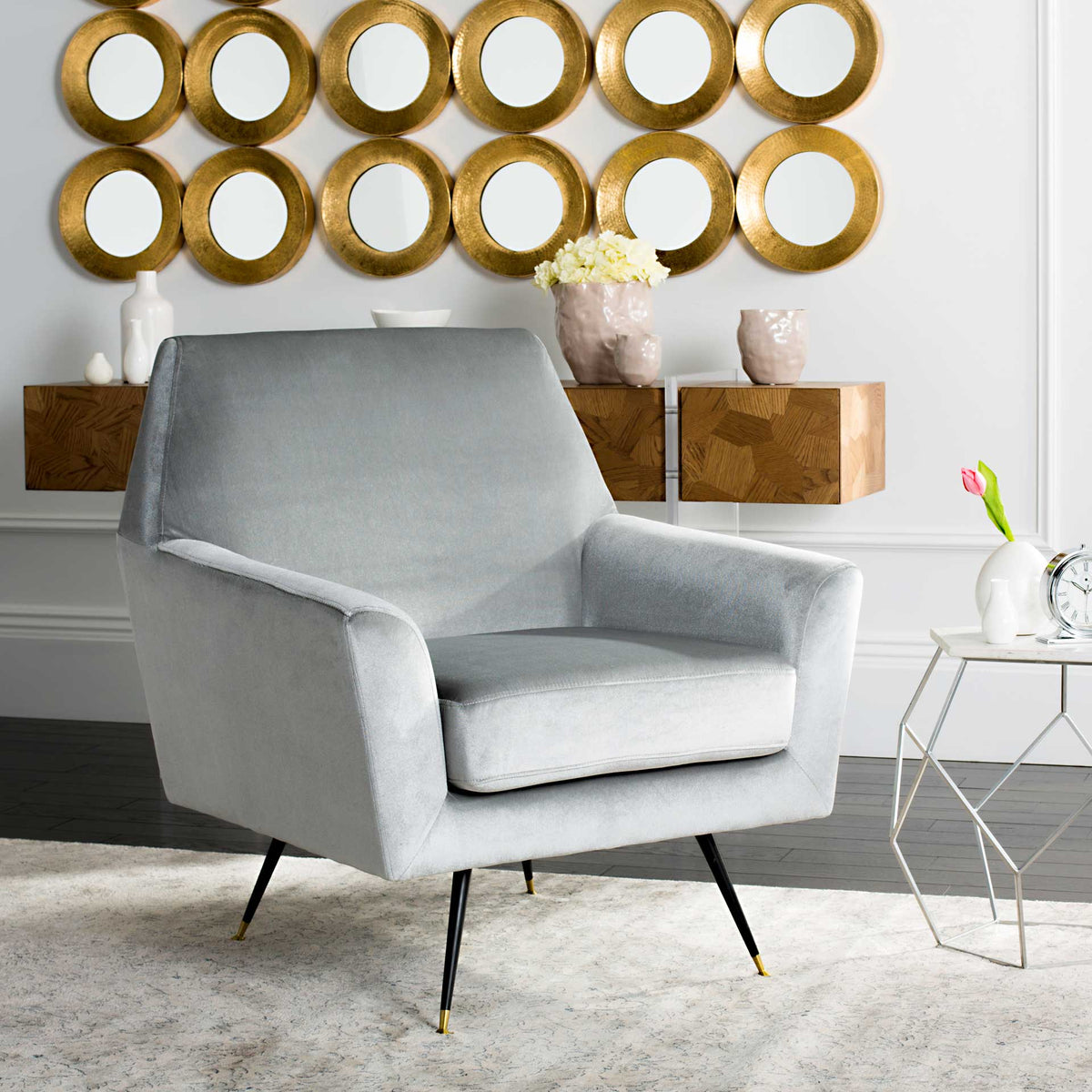 A light gray velvet chair brings plush comfort and midcentury character to a bright living space